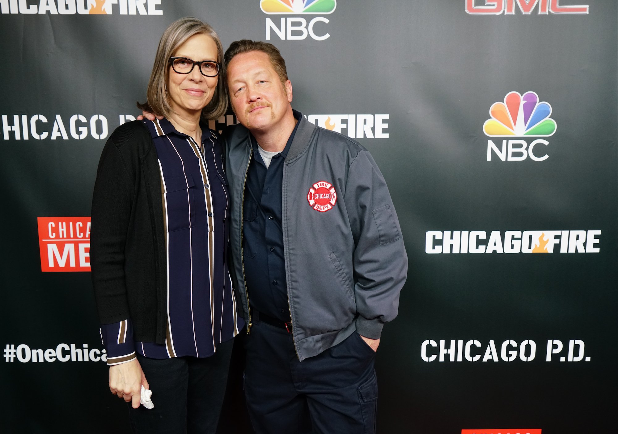 Amy Morton and Christian Stolte, embracing, smiling in front of a black background