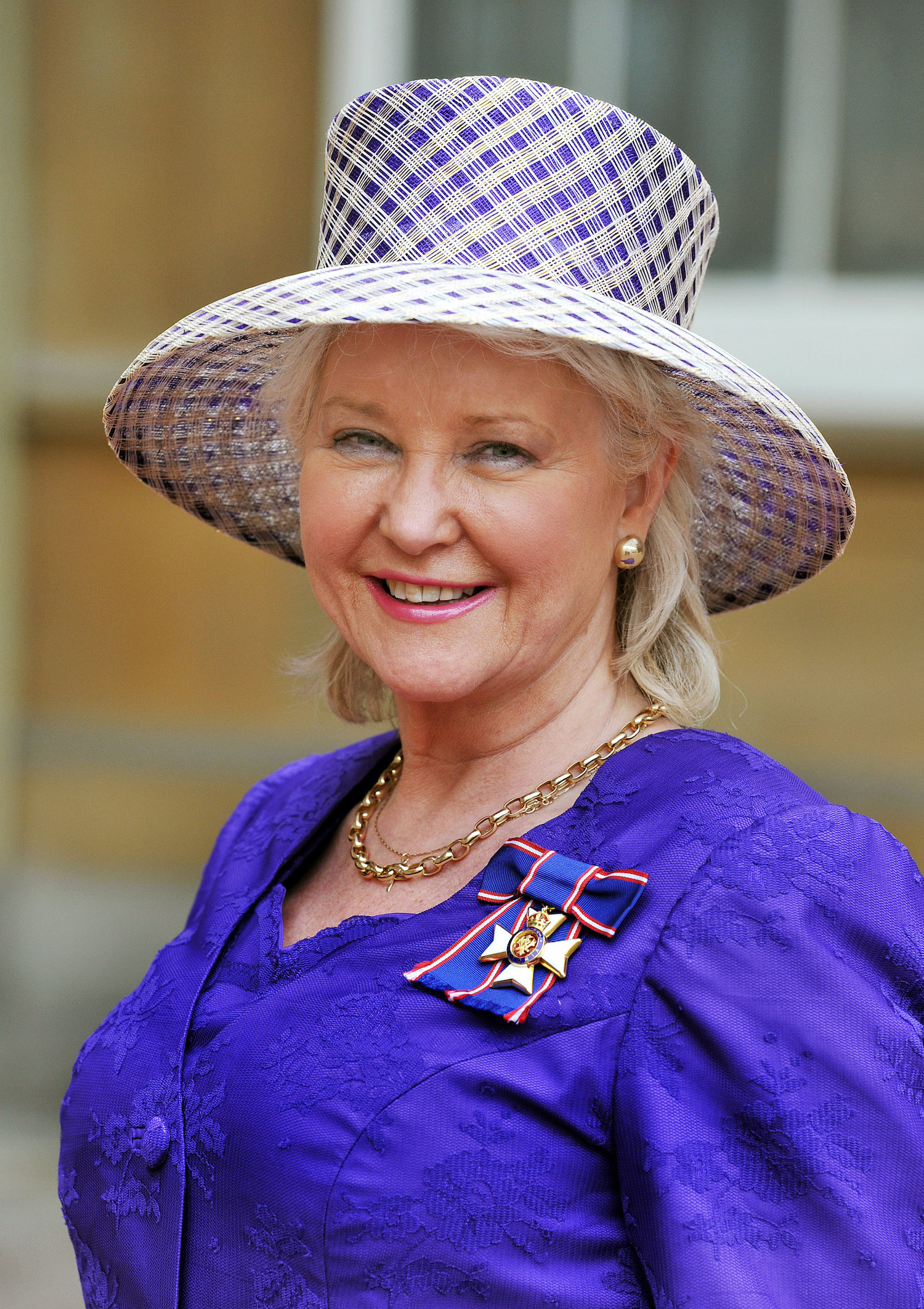 Angela Kelly smiles after receiving her Royal Victorian Order medal from Queen Elizabeth II in 2012