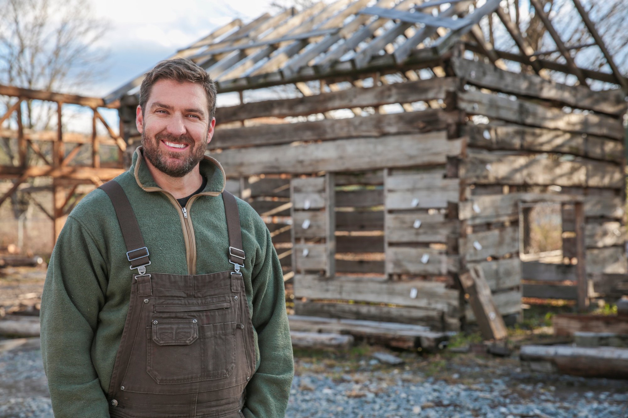 Mark Bowe smiling in front of a stripped down barn