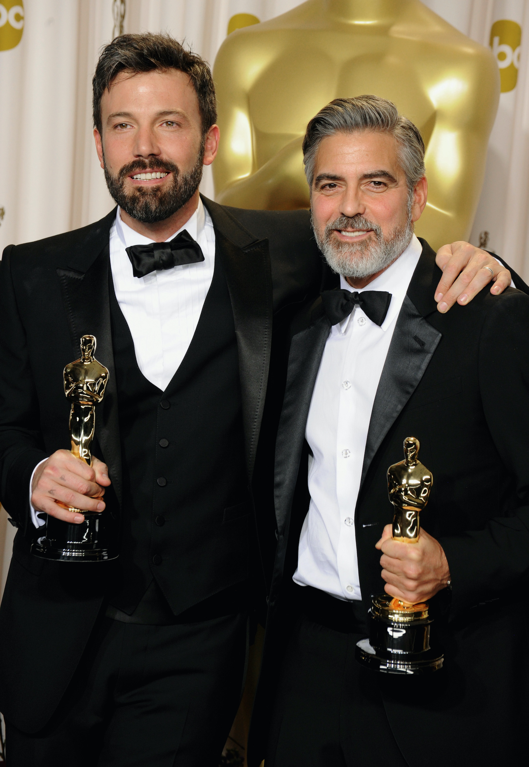 Ben Affleck and George Clooney at the 2013 Oscars posing with their Oscar statues