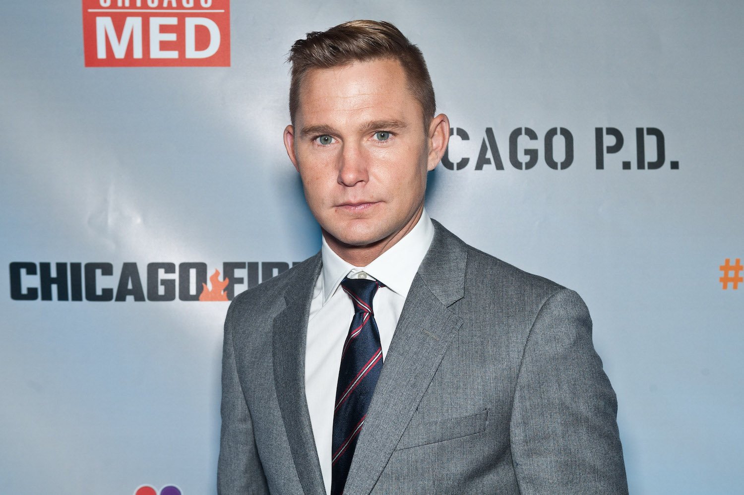 Brian Geraghty smiling in front of a light blue background