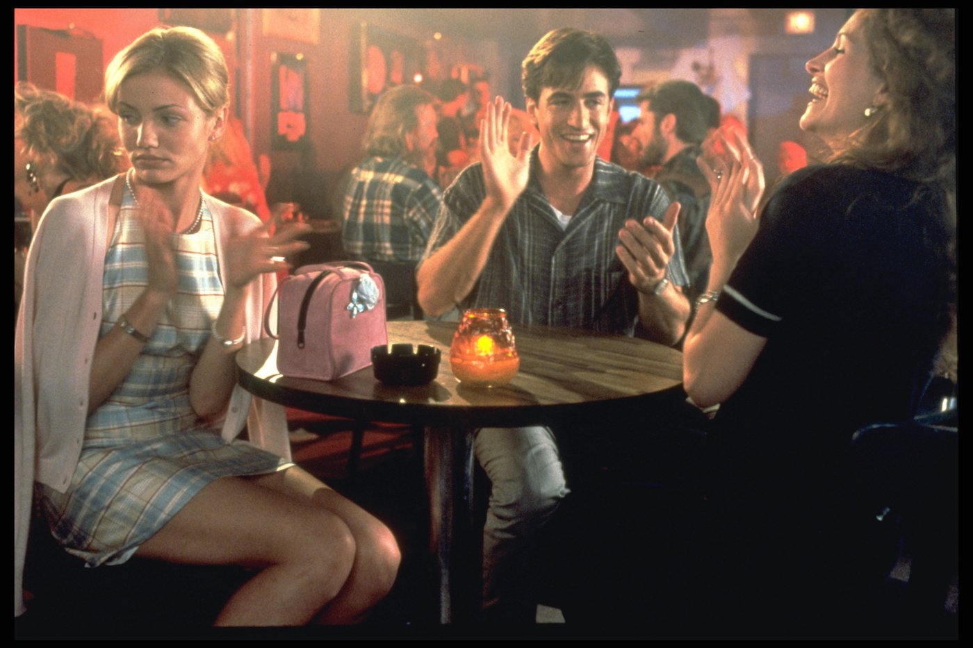 Cameron Diaz, Dermot Mulroney, and Julia Roberts sit at a table in a scene from 'My Best Friend's Wedding'
