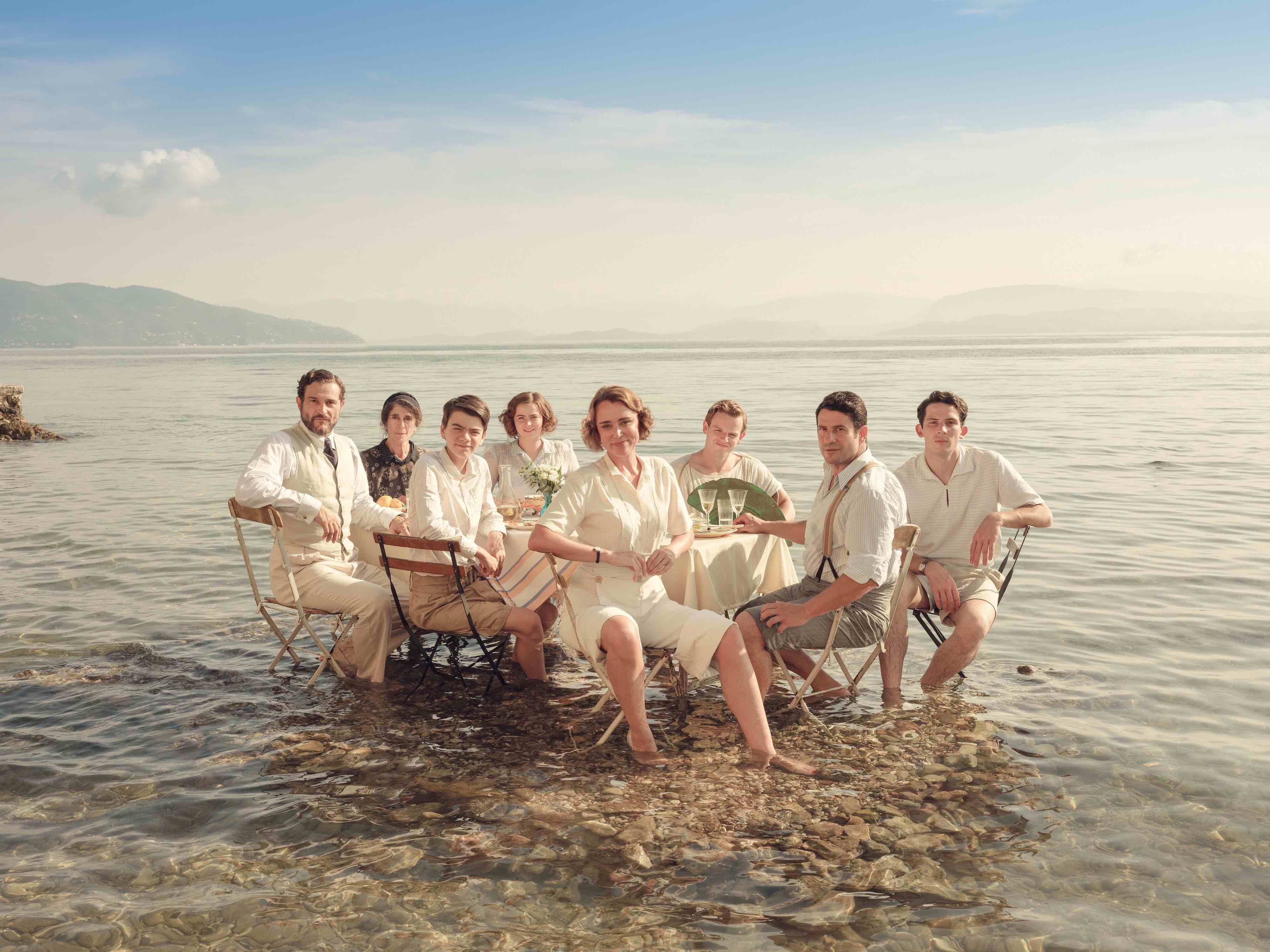 The Durrells sitting around a dining table in water