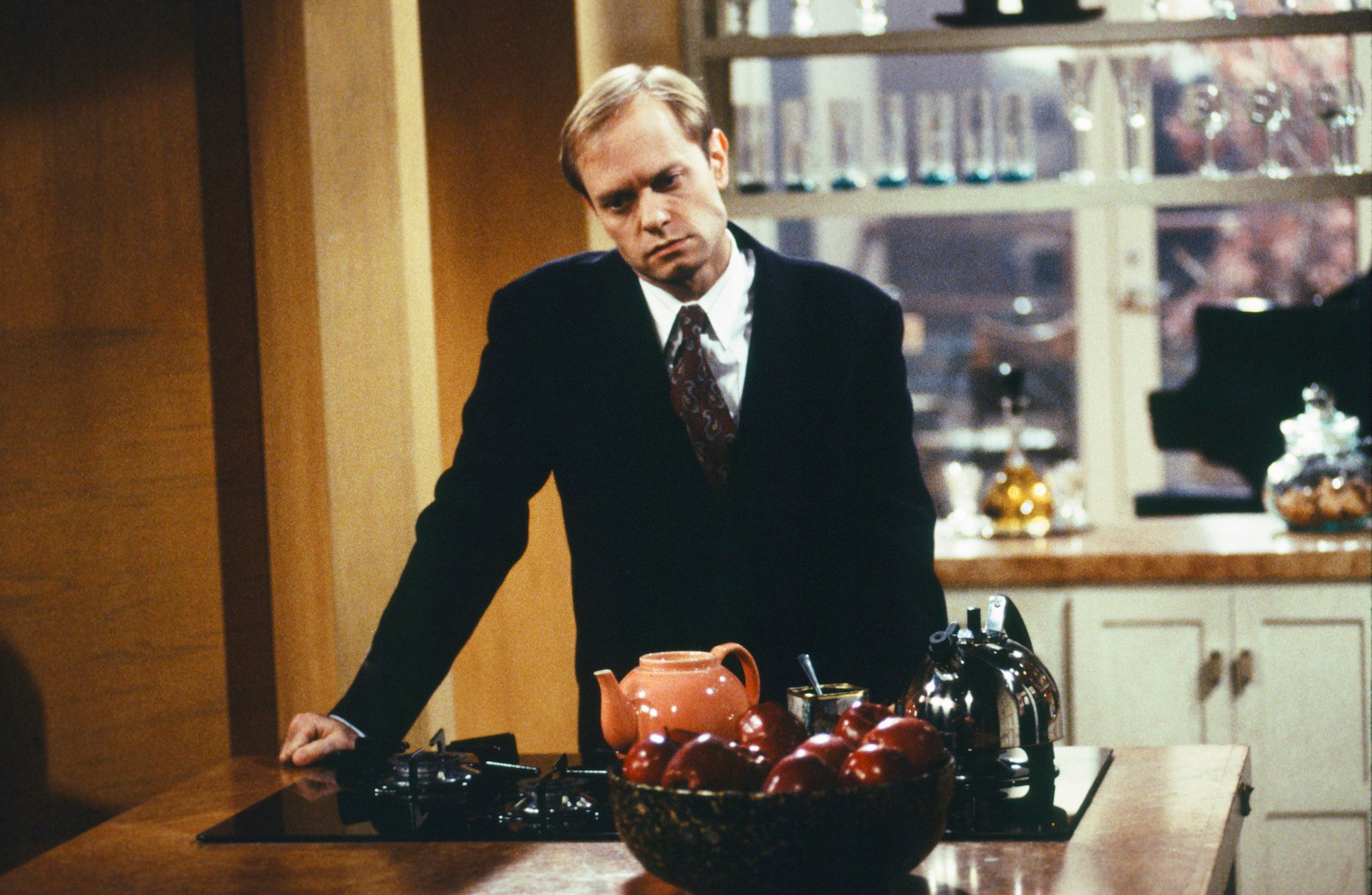 David Hyde Pierce as Dr. Niles Crane leaning over a counter