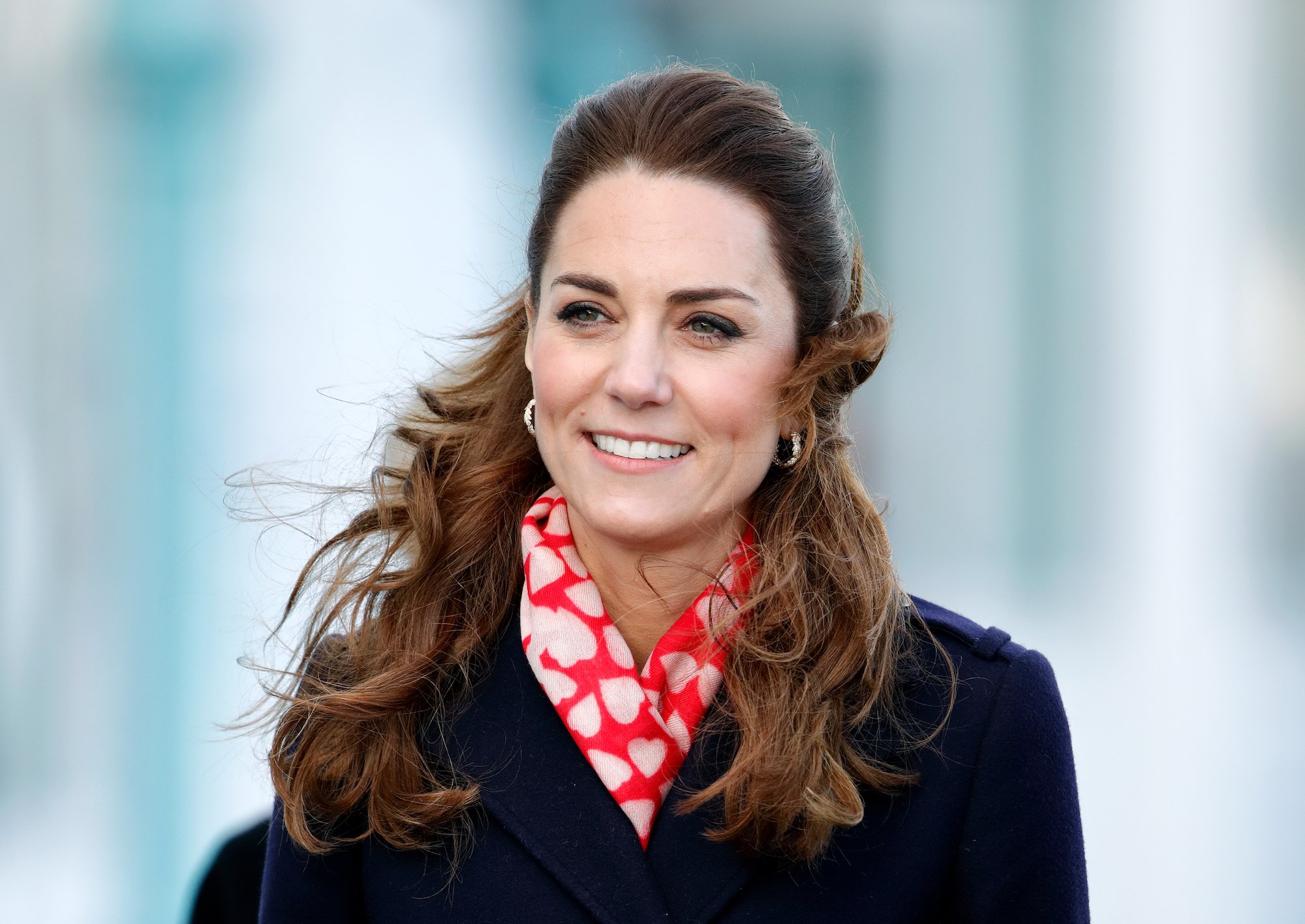 Kate Middleton smiling, looking off camera, hair blowing forward