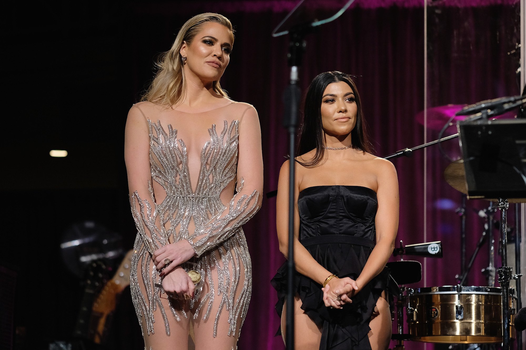 Khloé Kardashian and Kourtney Kardashian on a stage smiling