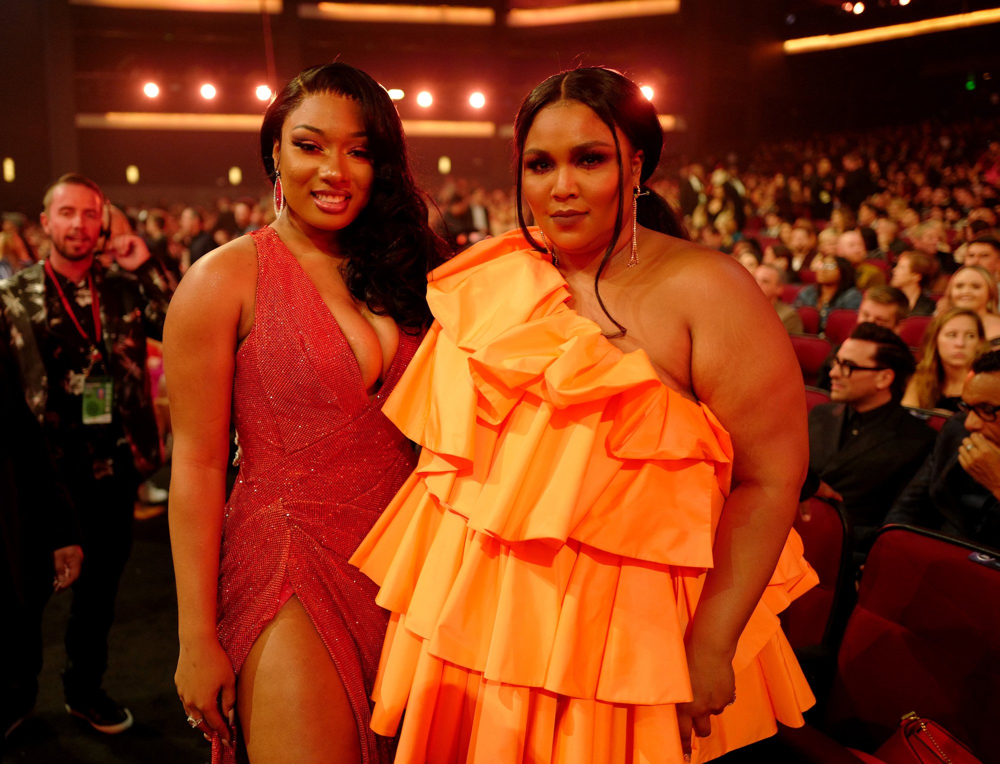 Megan Thee Stallion smiling, standing next to Lizzo