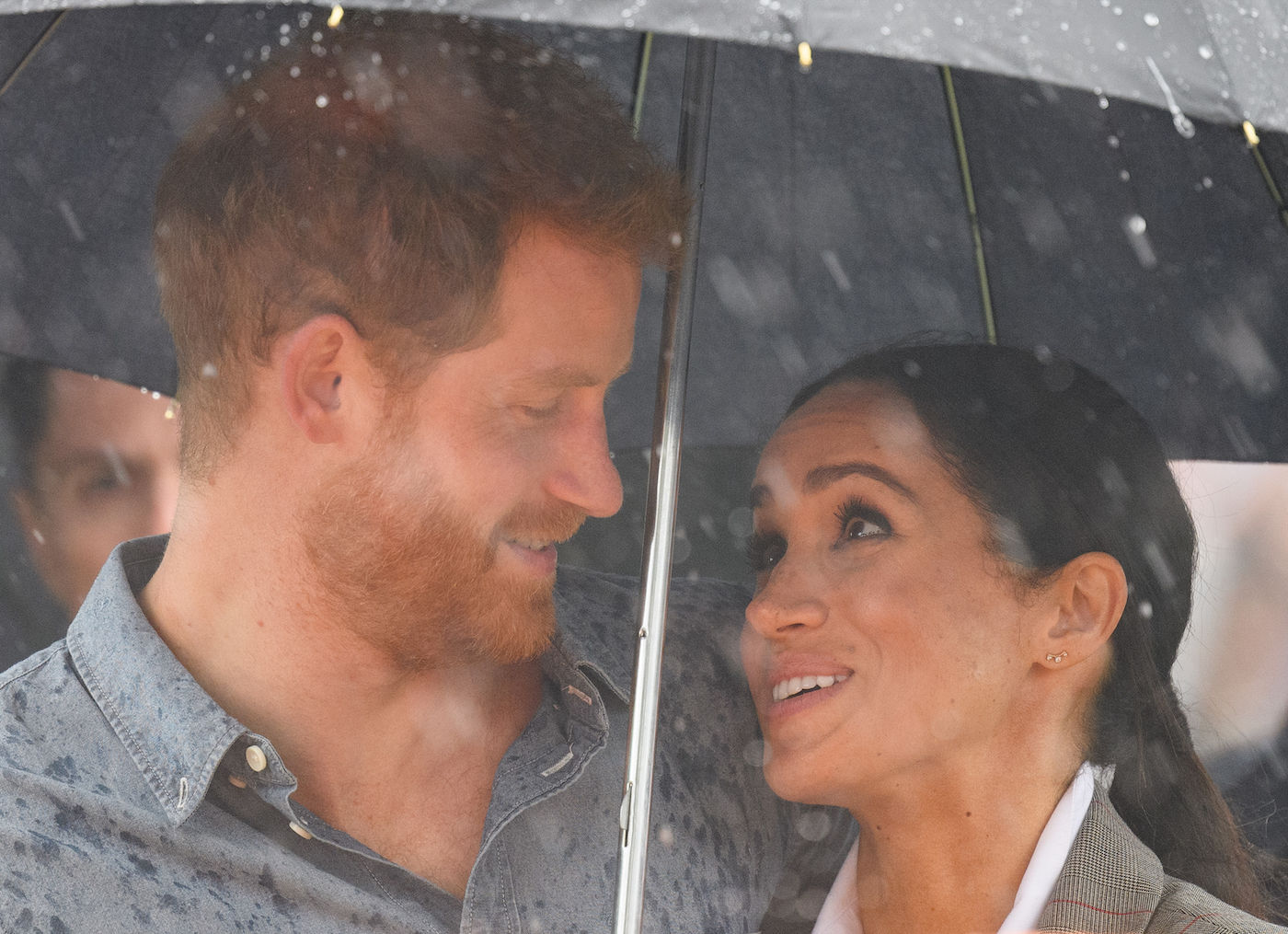 Prince Harry and Meghan Markle stand under an umbrella during a visit to Dubbo, Australia