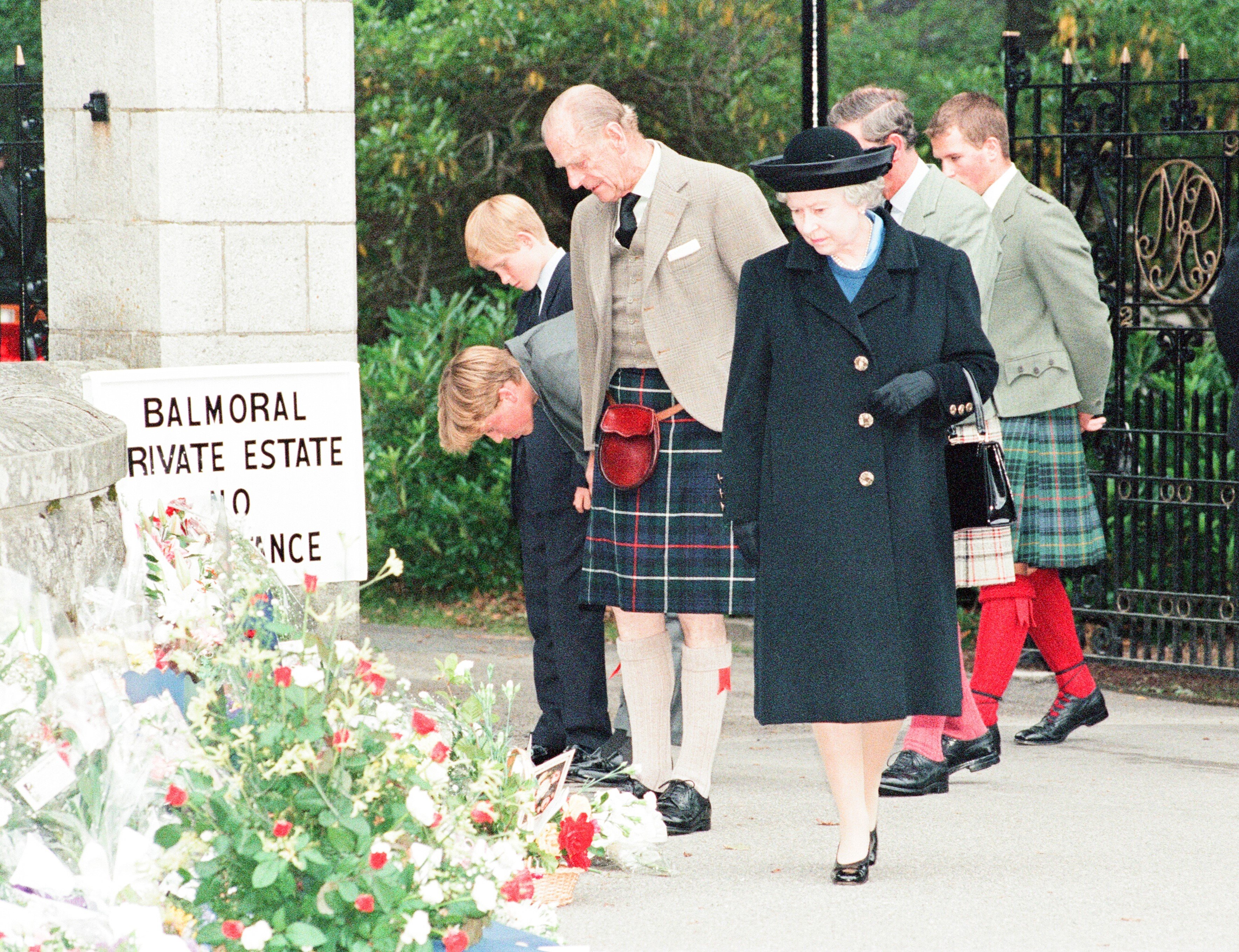 Queen Elizabeth II, Prince Philip, Prince Charles, Prince William, Prince Harry, and Peter Phillips look at Princess Diana tributes outside Balmoral