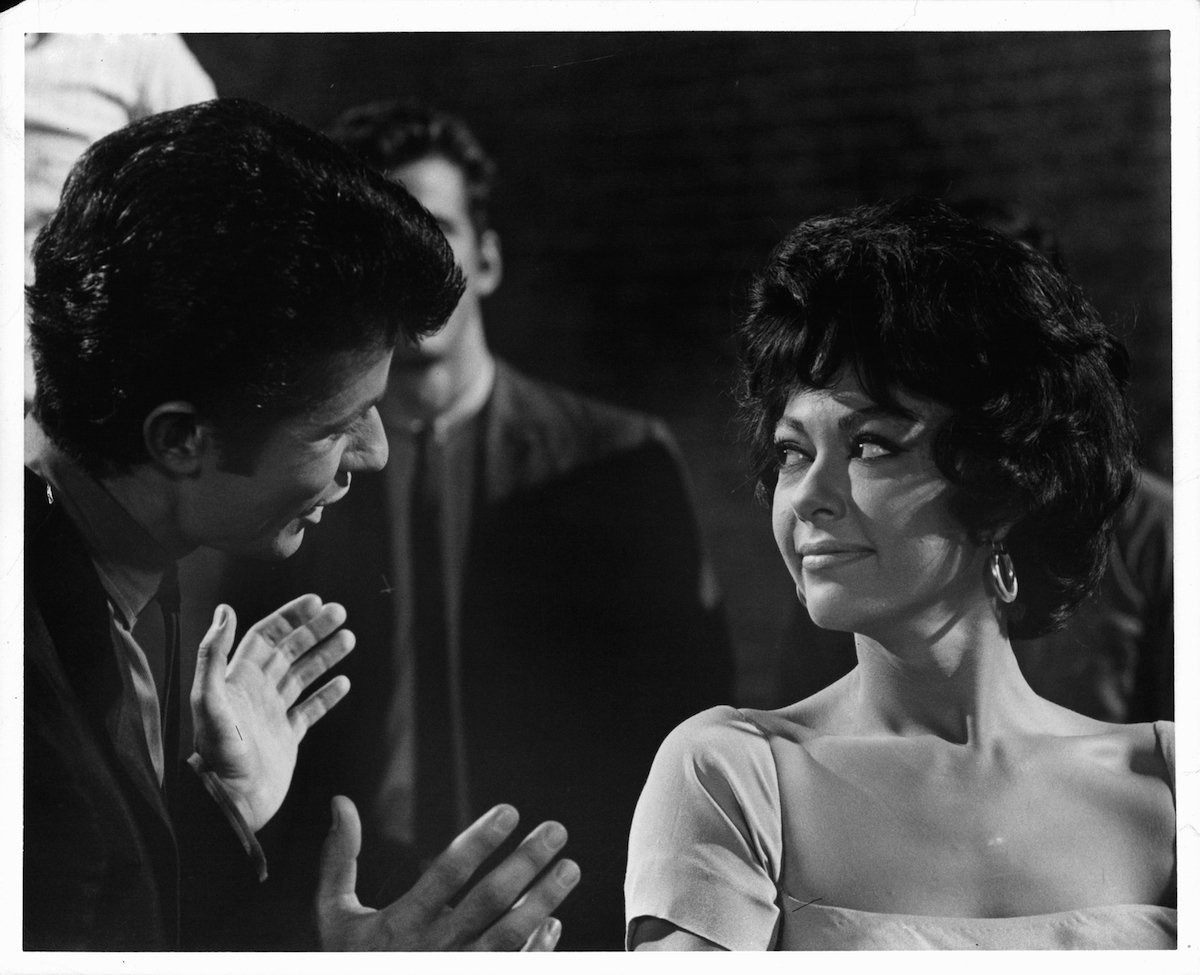 Rita Moreno listens while George Chakiris speaks with her in a scene from 'West Side Story' (1961) 