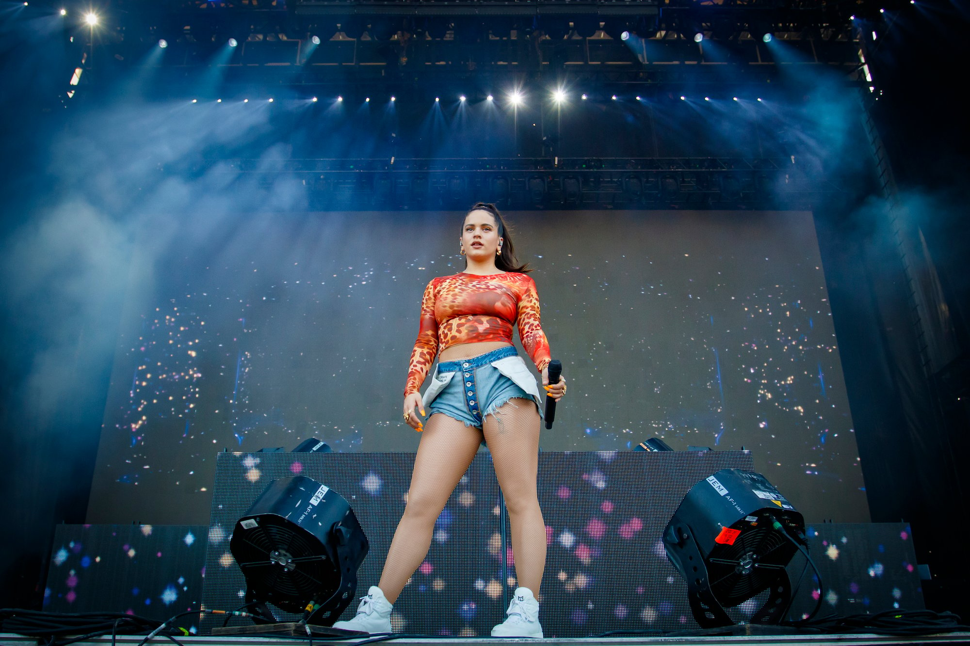 Rosalía on stage holding a microphone