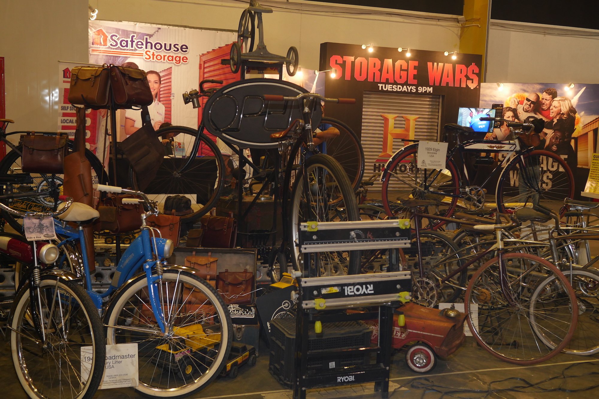 Storage Wars display full of old bikes, hardware, signs, and bags