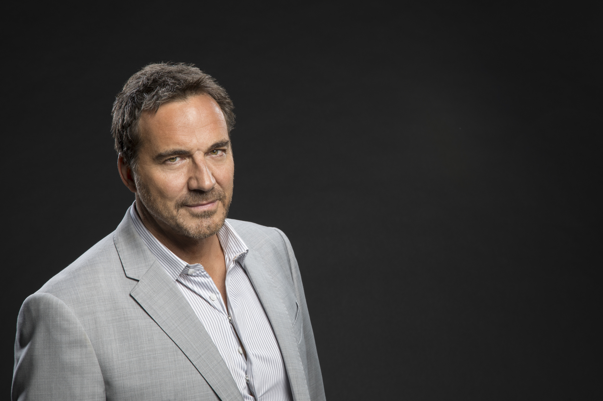 Thorsten Kaye smiling in front of a black background