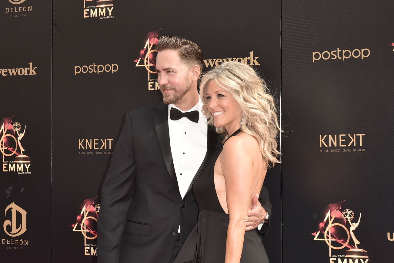 Wes Ramsey and Laura Wright poses together in front of dark background