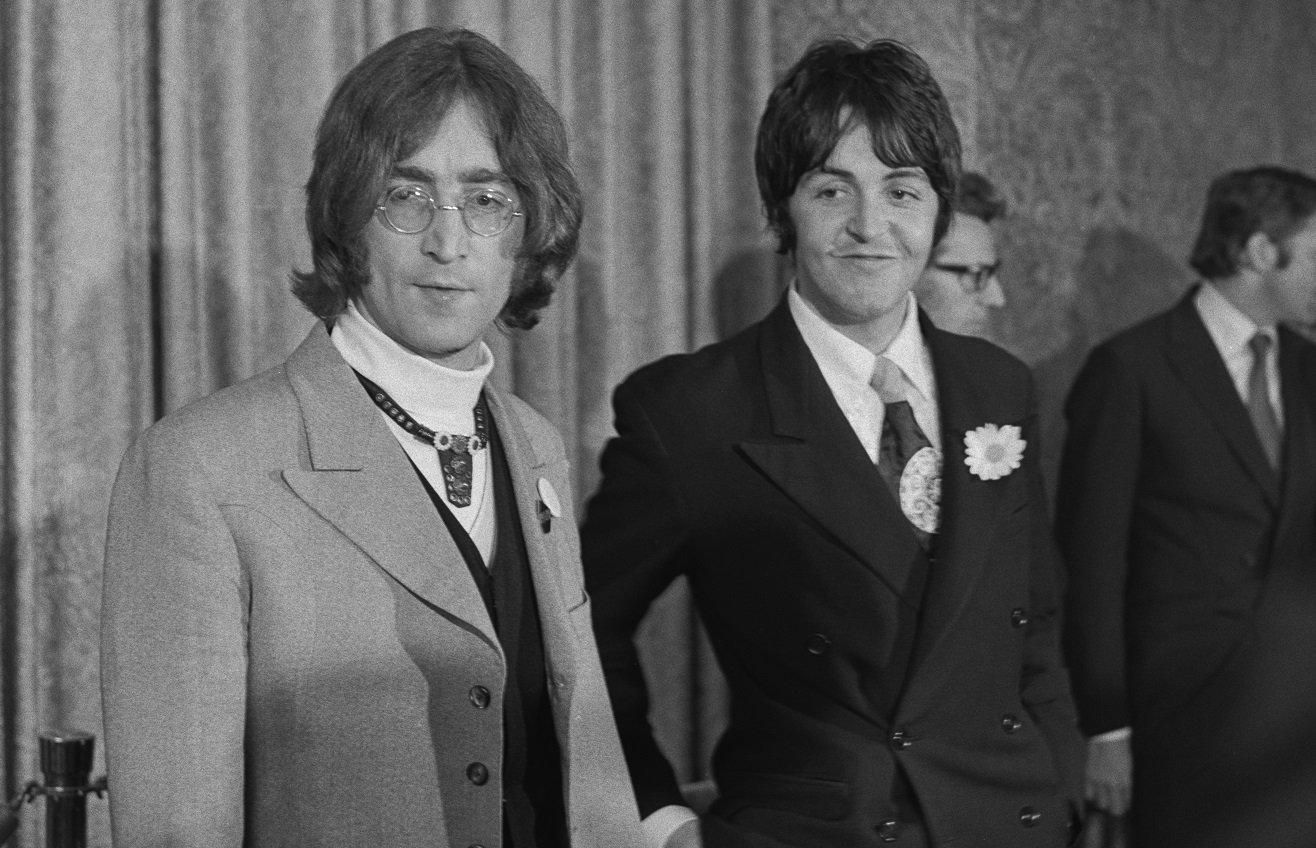 John Lennon and Paul McCartney standing before the press