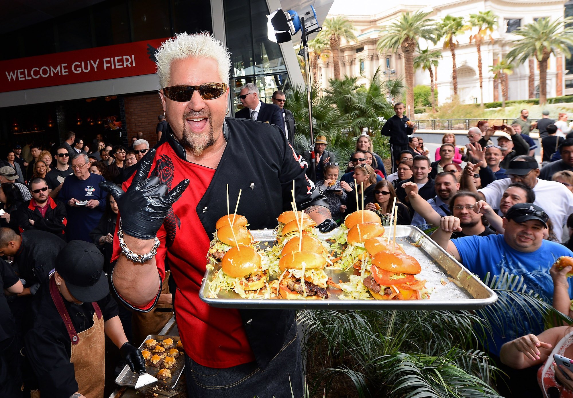 Guy Fieri serves hamburgers to guests at his restaurant.