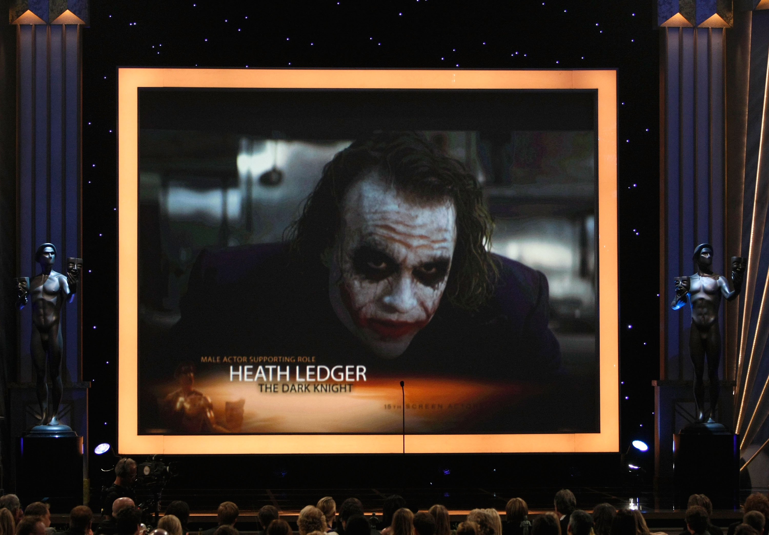 A screen projecting an image of Heath Ledger as the Joker
