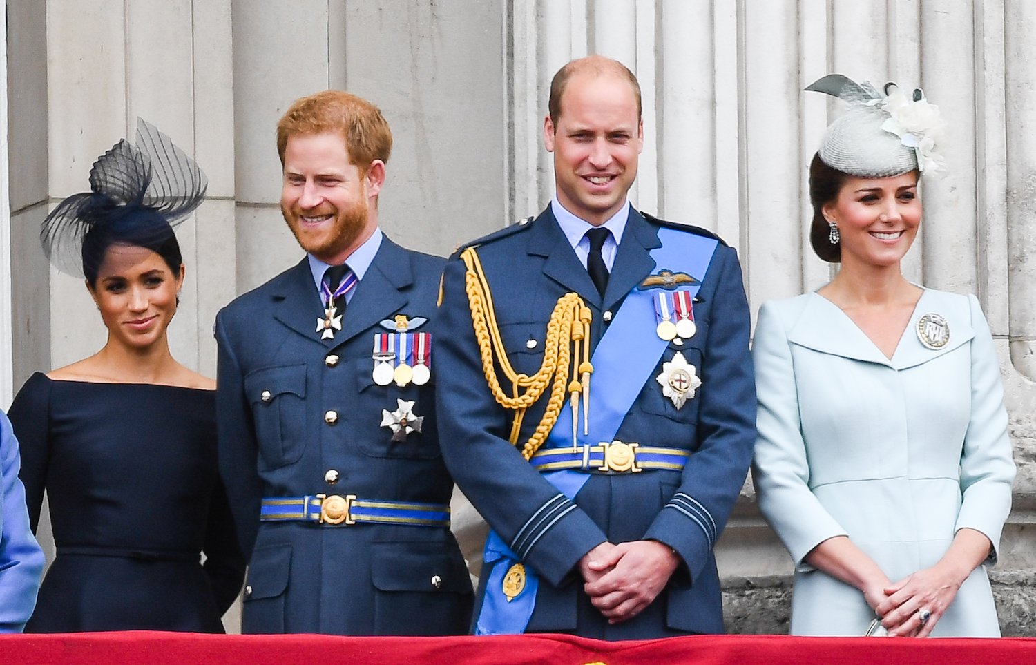 Meghan Markle, Prince Harry, Prince William, and Kate Middleton stand on the balcony of Buckingham Palace to view a flypast to mark the centenary of the Royal Air Force (RAF)