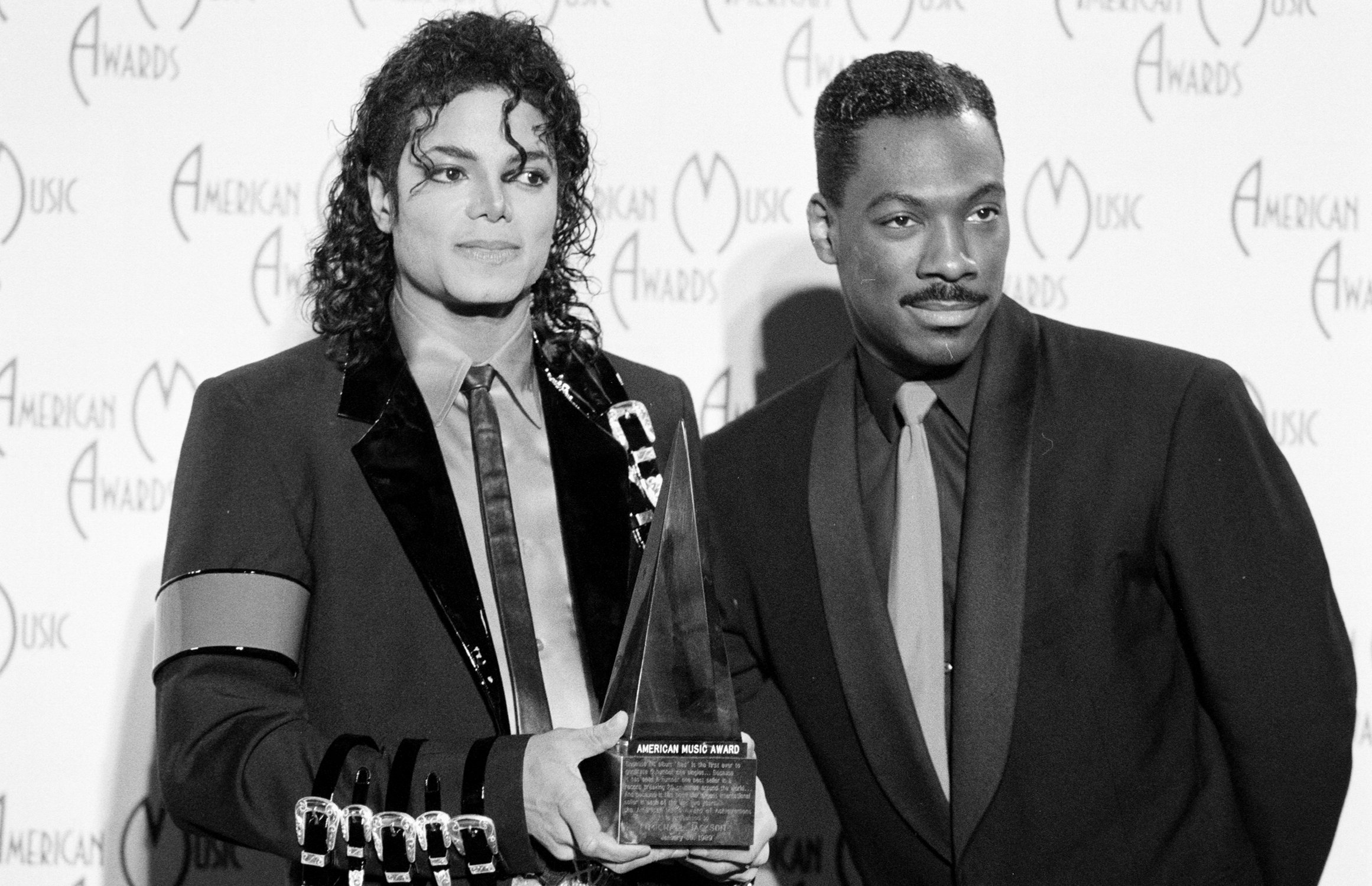 Michael Jackson holding an award next to Eddie Murphy