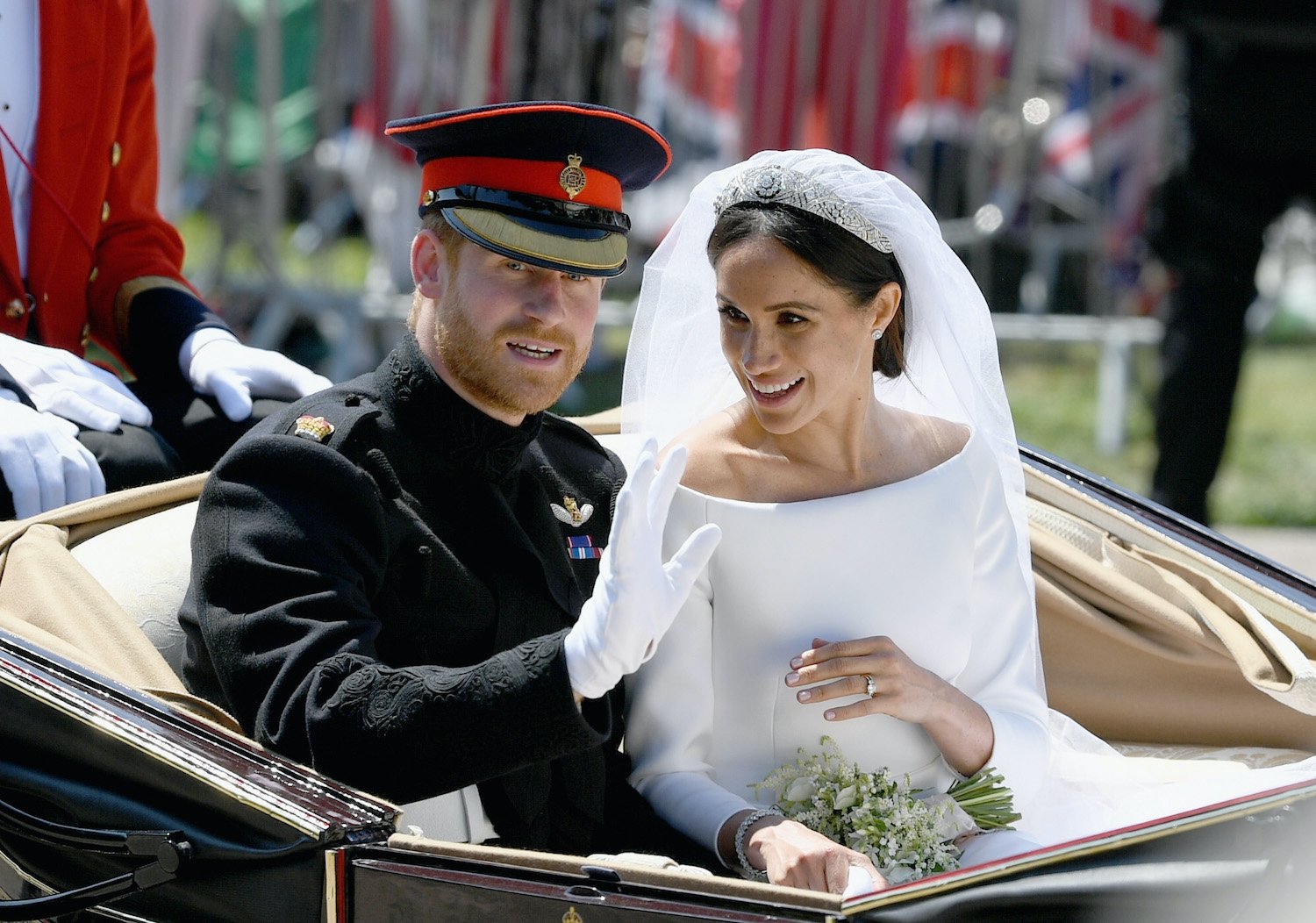 Prince Harry and Meghan Markle wave from the Ascot Landau Carriage during their carriage procession after their wedding ceremony