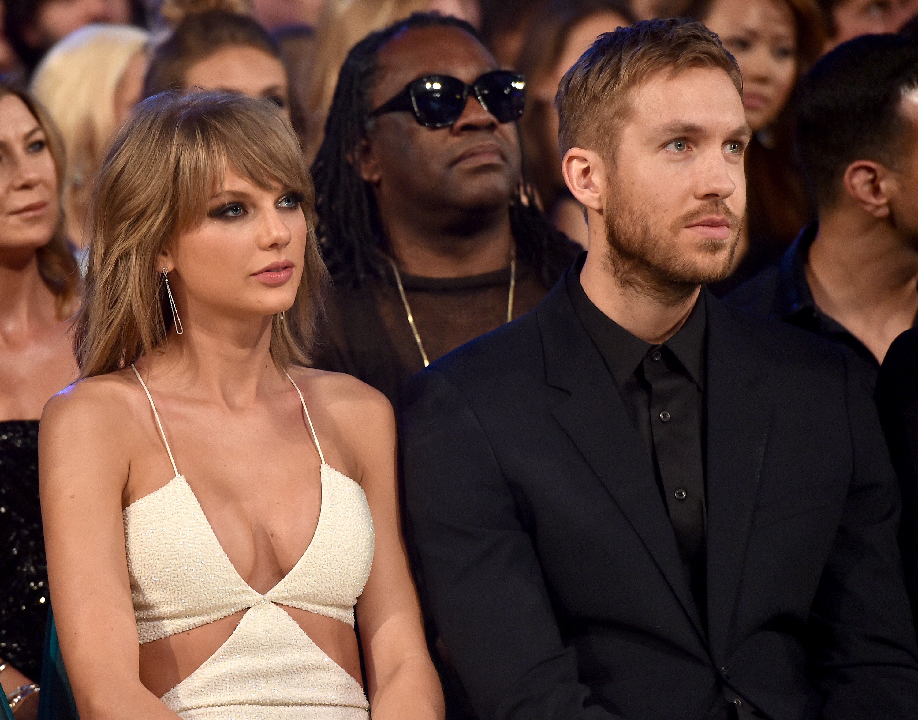 Taylor Swift and Calvin Harris seated in a crowd