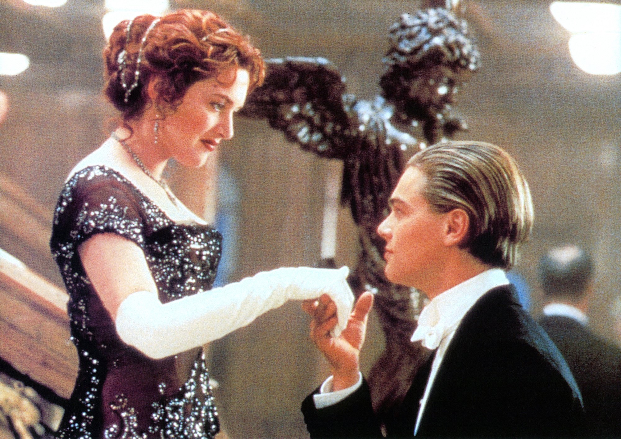 Kate Winslet offers her hand to Leonardo DiCaprio in a scene from the film 'Titanic', 1997.