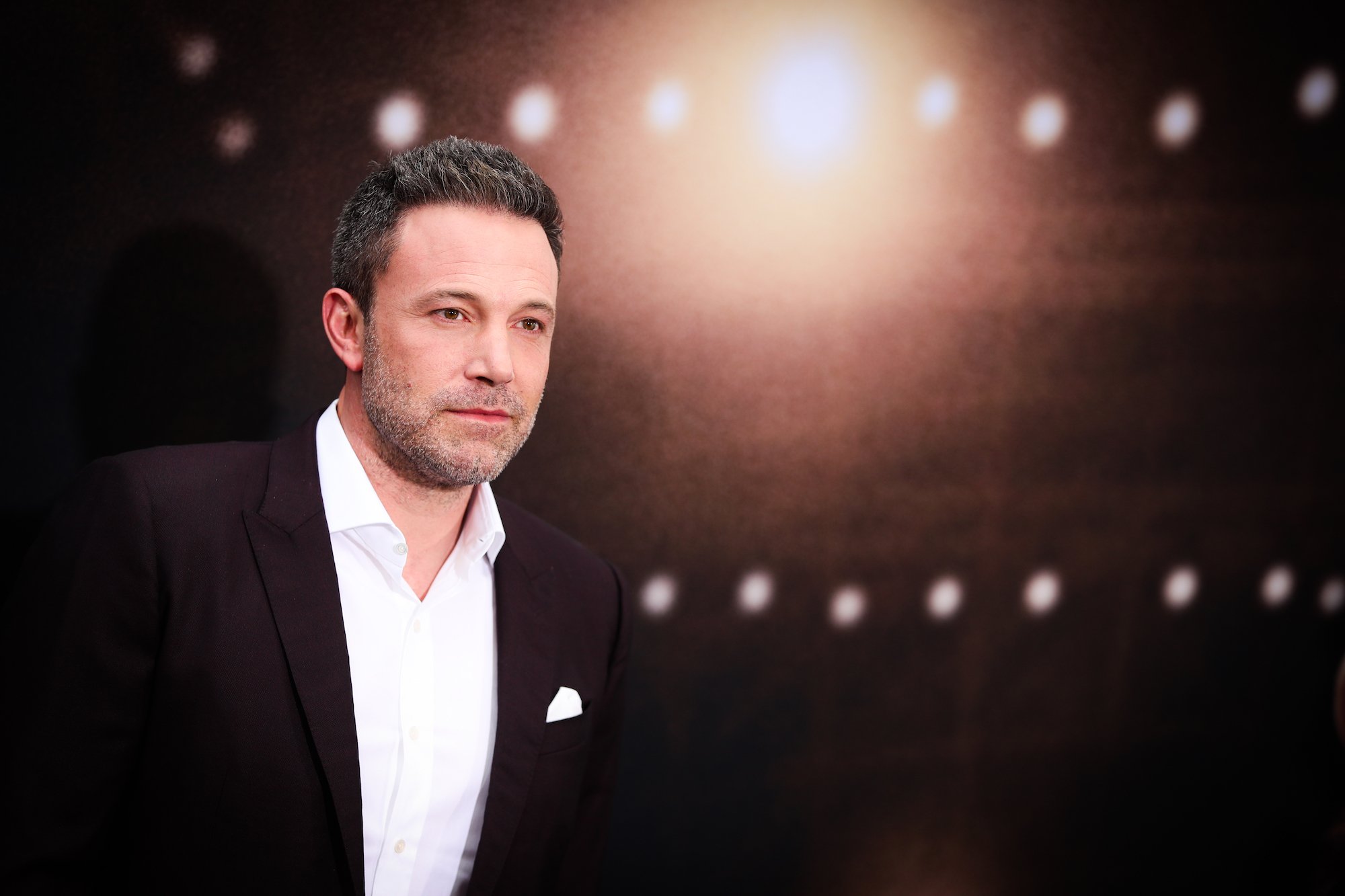 Ben Affleck smiling slightly in front of a dark background