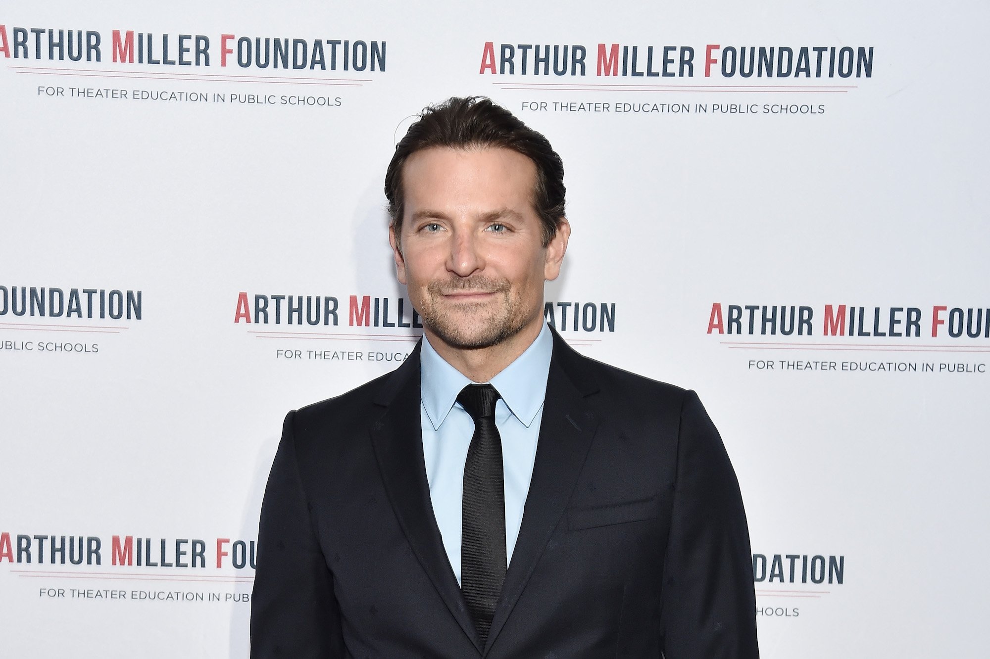 Bradley Cooper slightly smiling in front of a white background