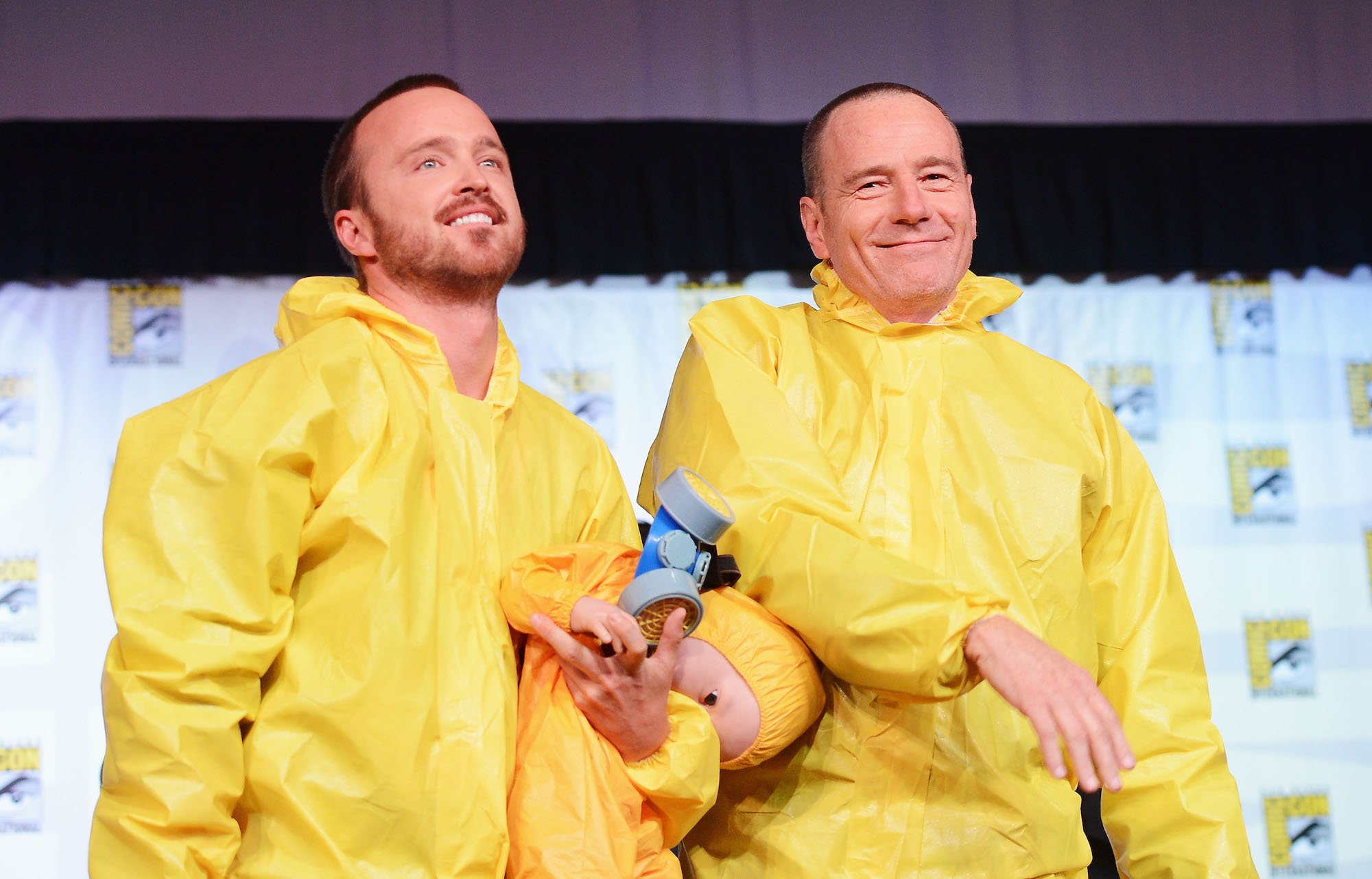 (L-R) Aaron Paul and Bryan Cranston smiling in yellow suits
