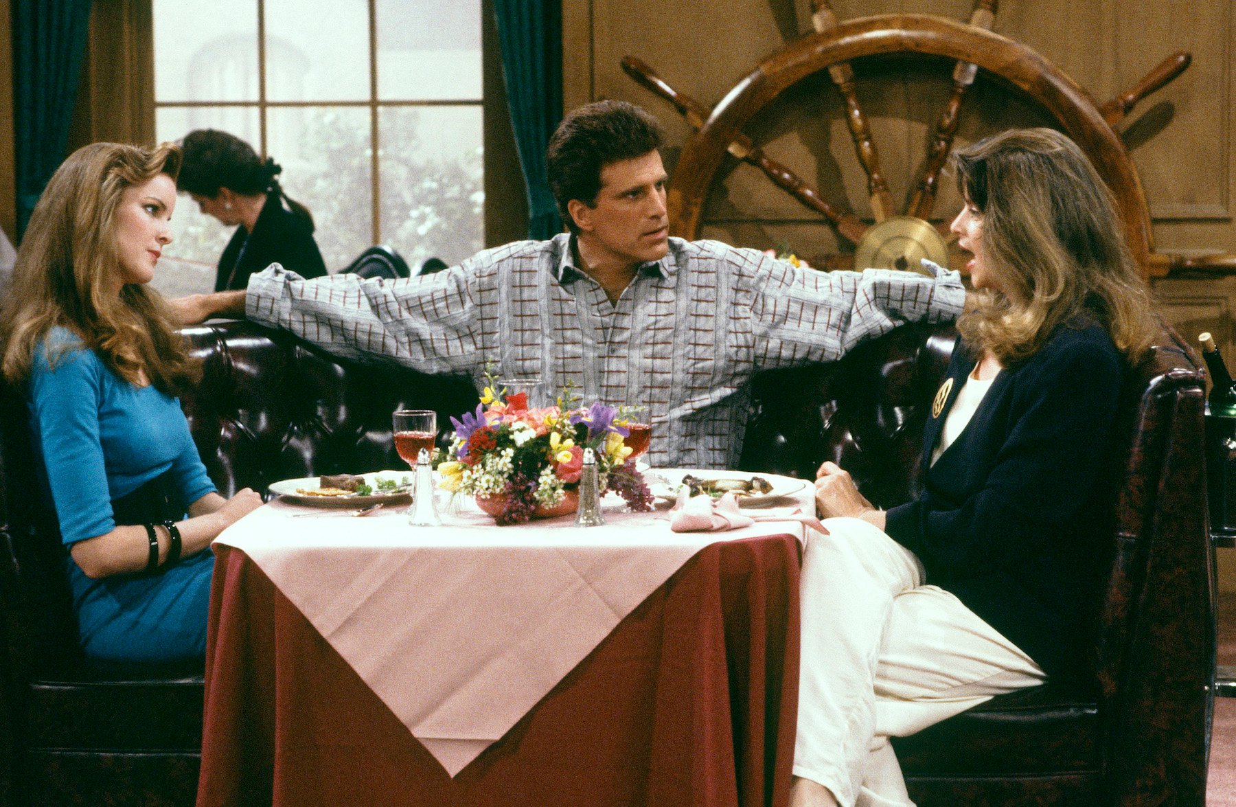 (L-R) Marcia Cross as Susan Howe, Ted Danson as Sam Malone, Kirstie Alley as Rebecca Howe at a table in front of a large ship wheel