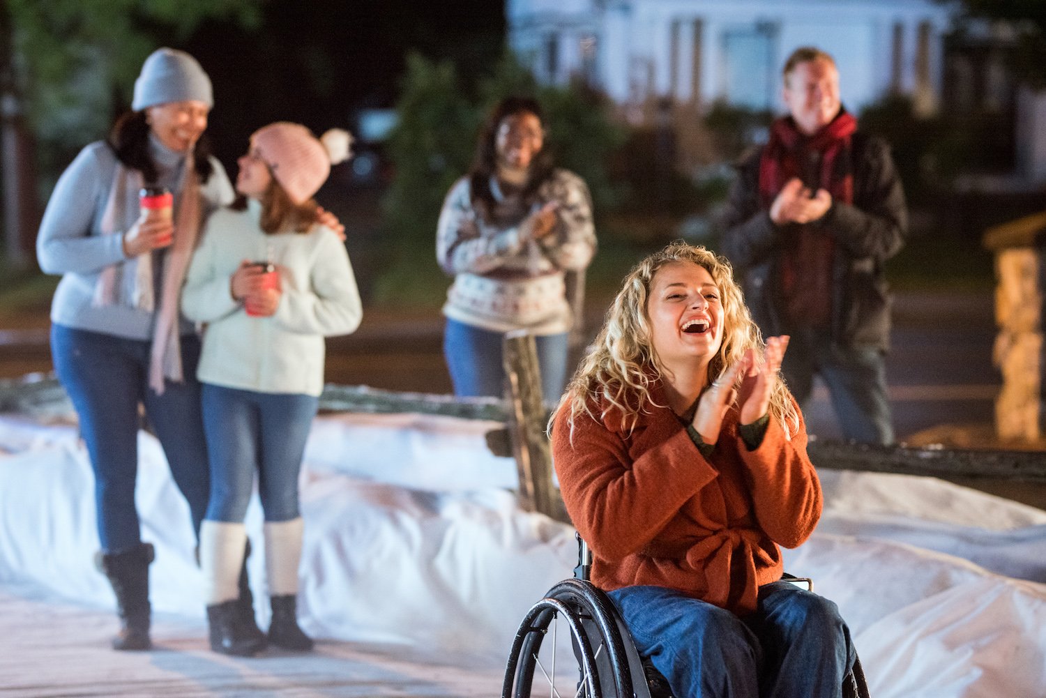 Blonde woman in a wheelchair clapping