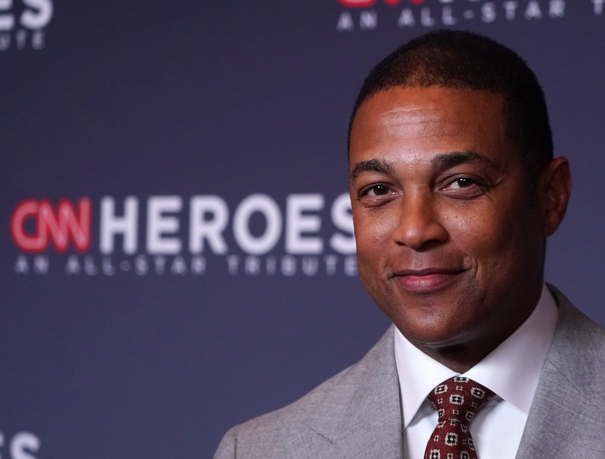Don Lemon smiling in front of a blue background