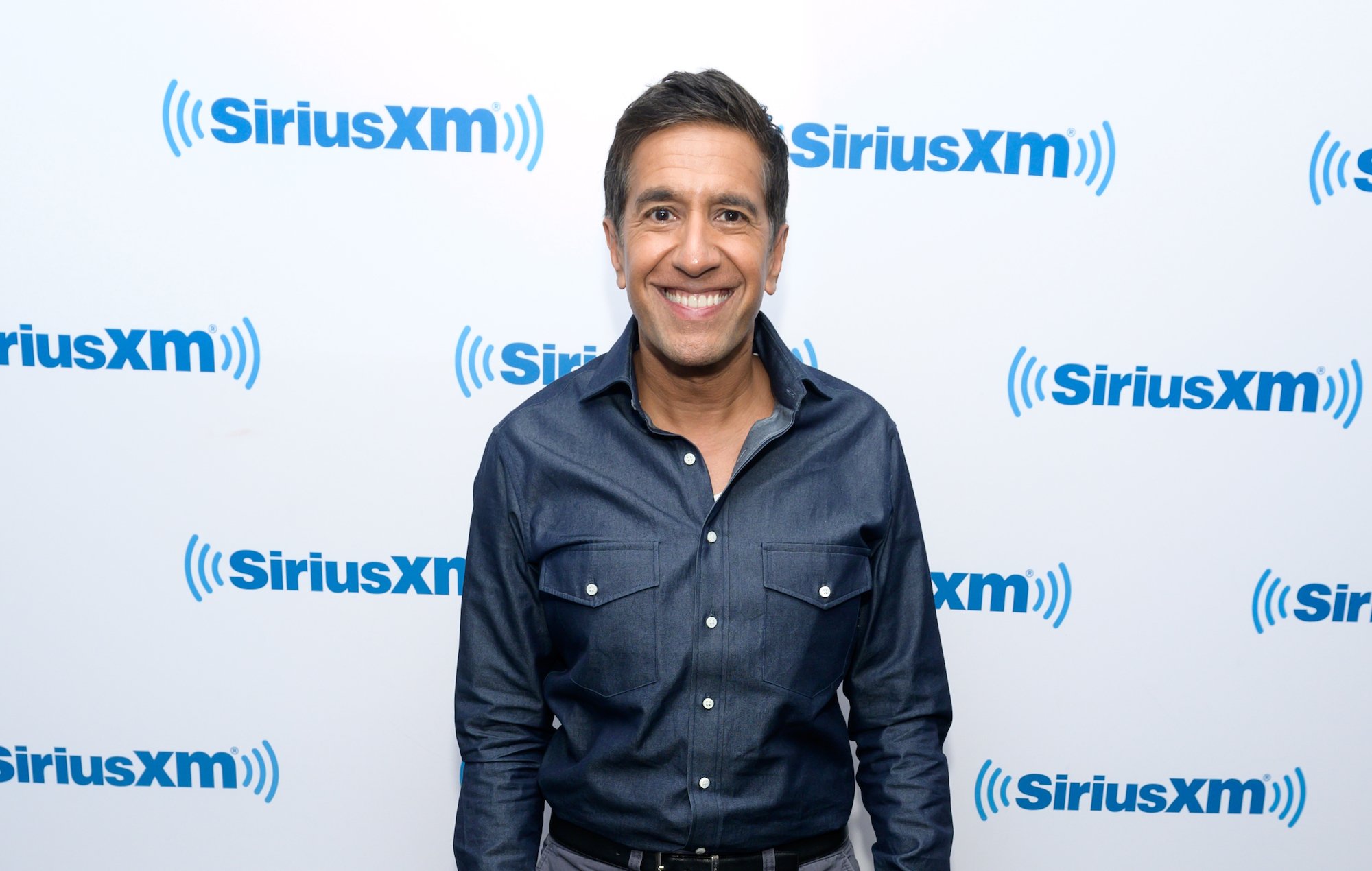 Dr. Sanjay Gupta smiling in front of a white background