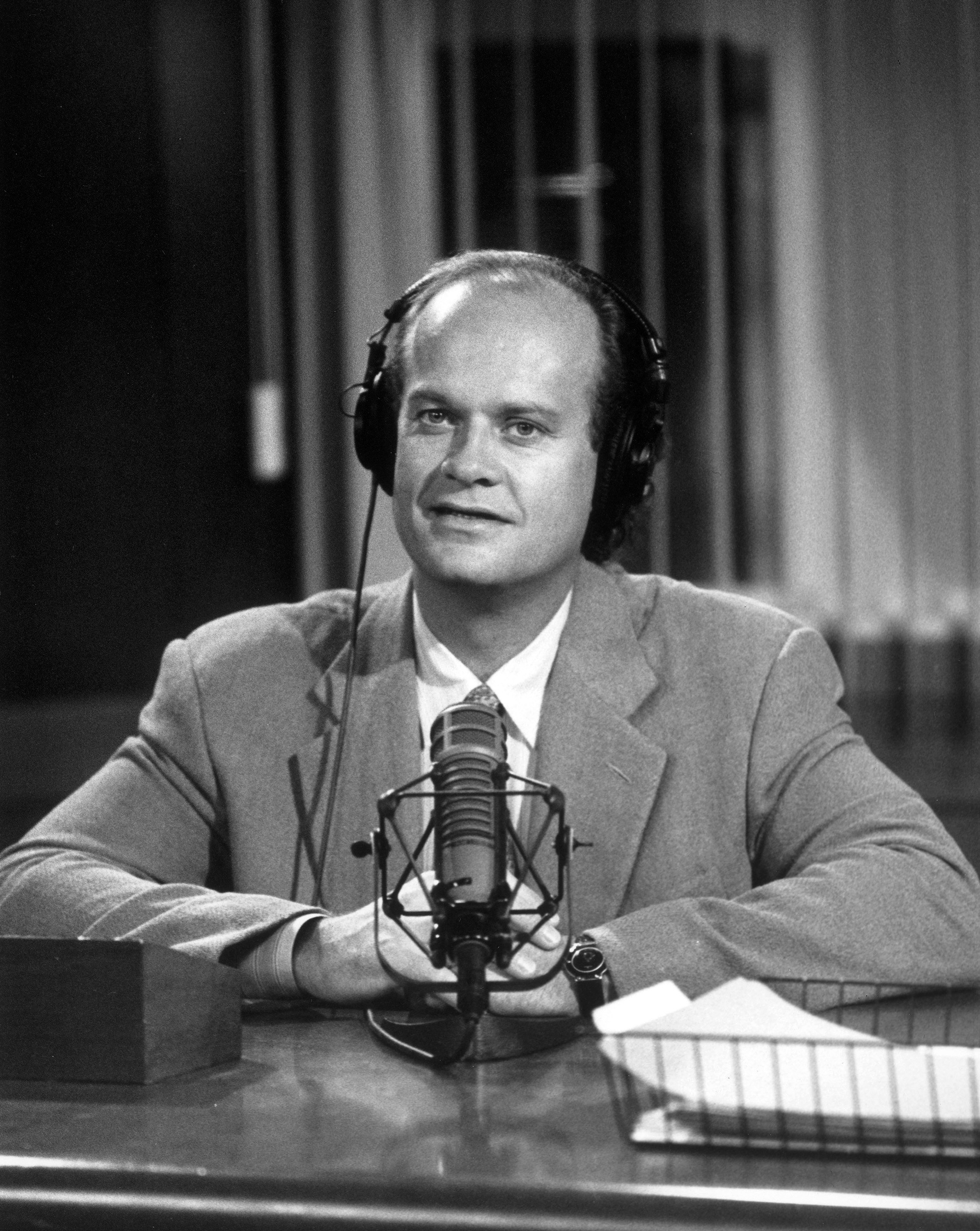 Dr. Frasier Crane sitting at his desk at the radio station