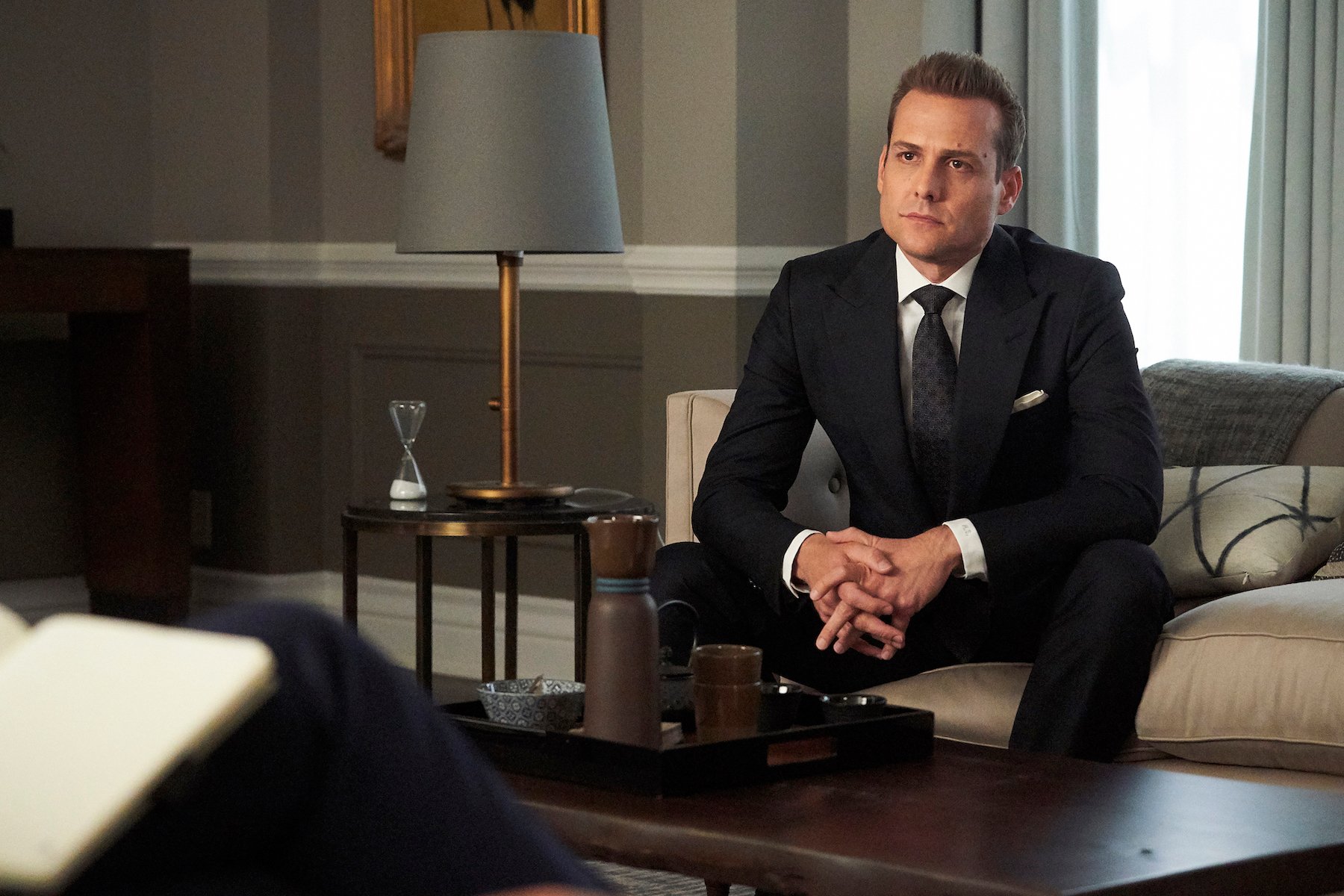 Gabriel Macht as Harvey Spencer on 'Suits' sitting with his hands folded