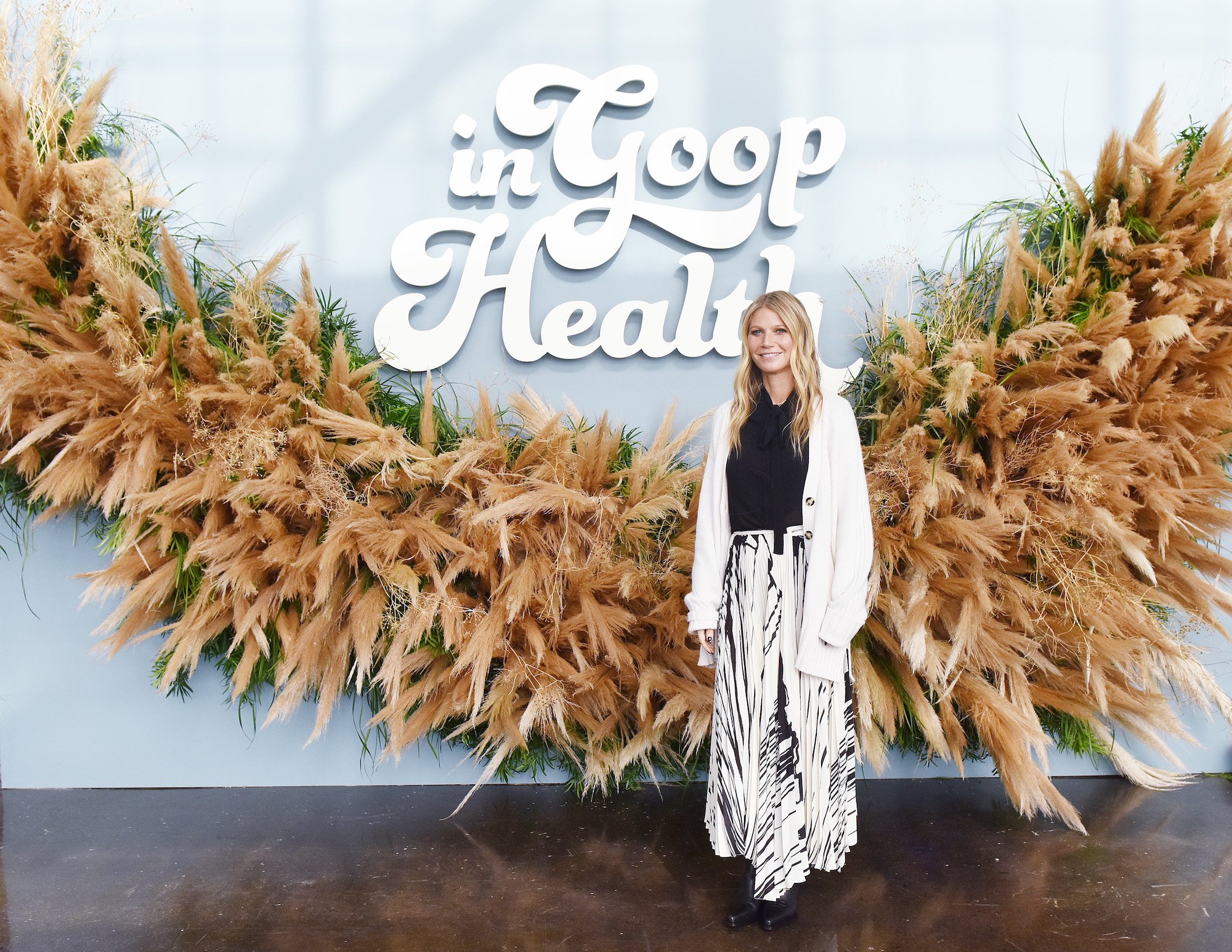 Gwyneth Paltrow smiling in front of a giant wreath