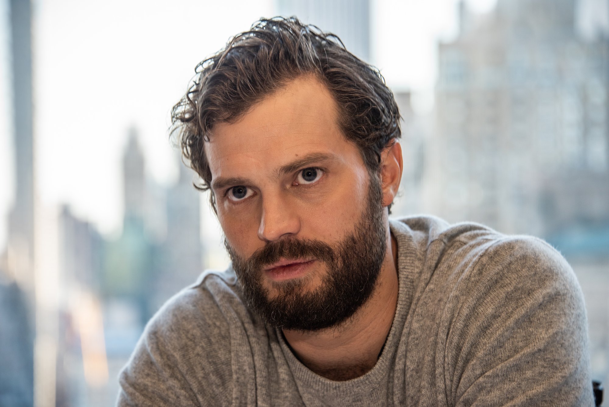 Jamie Dornan in front of a blurred background