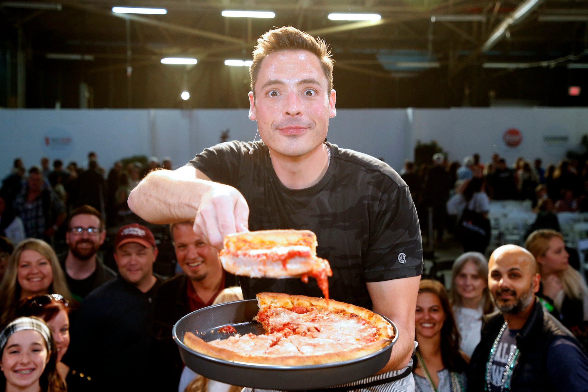 Jeff Mauro demonstrates a cooking technique onstage