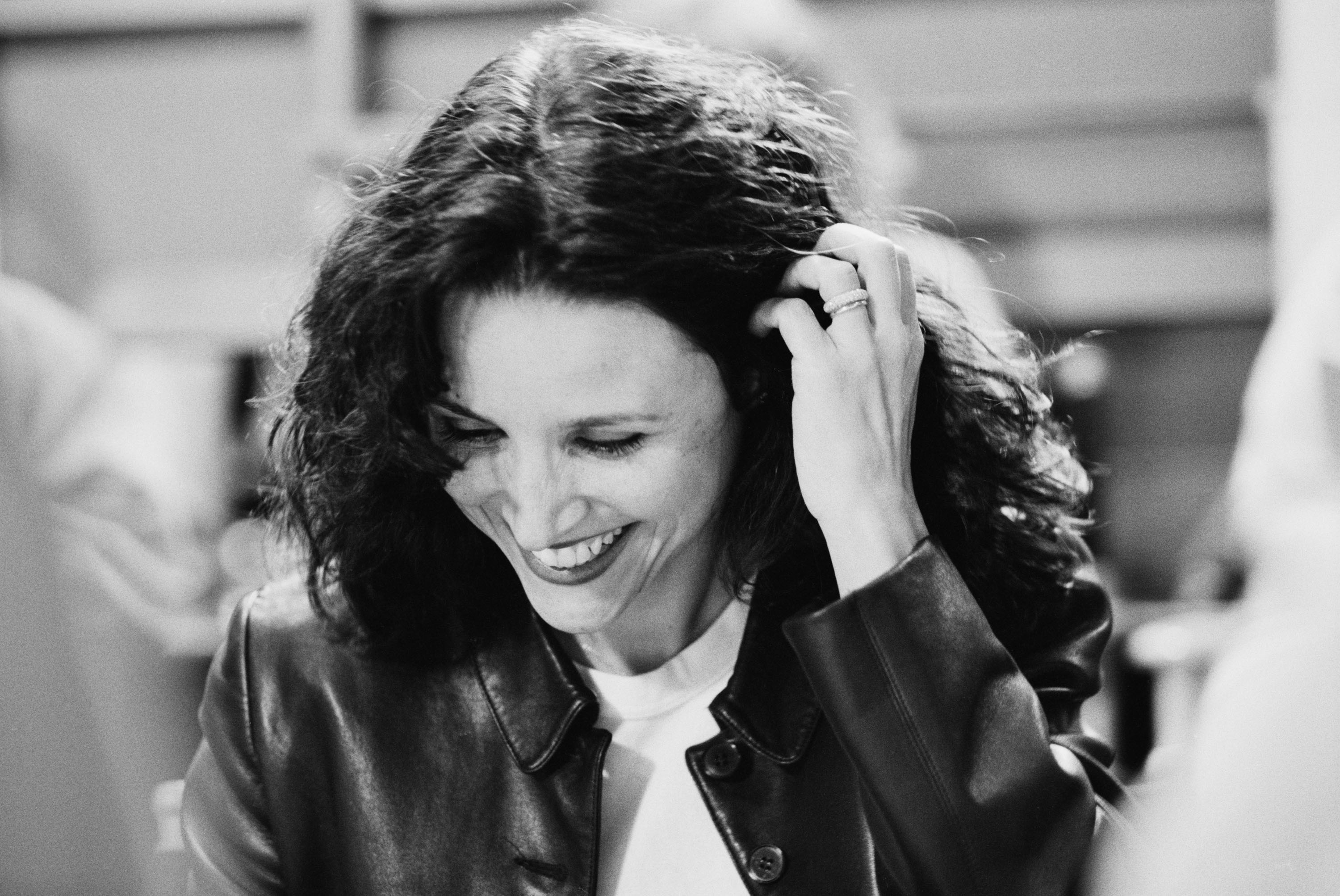 Julia Louis-Dreyfus smiles as she reads a script for 'Seinfeld'