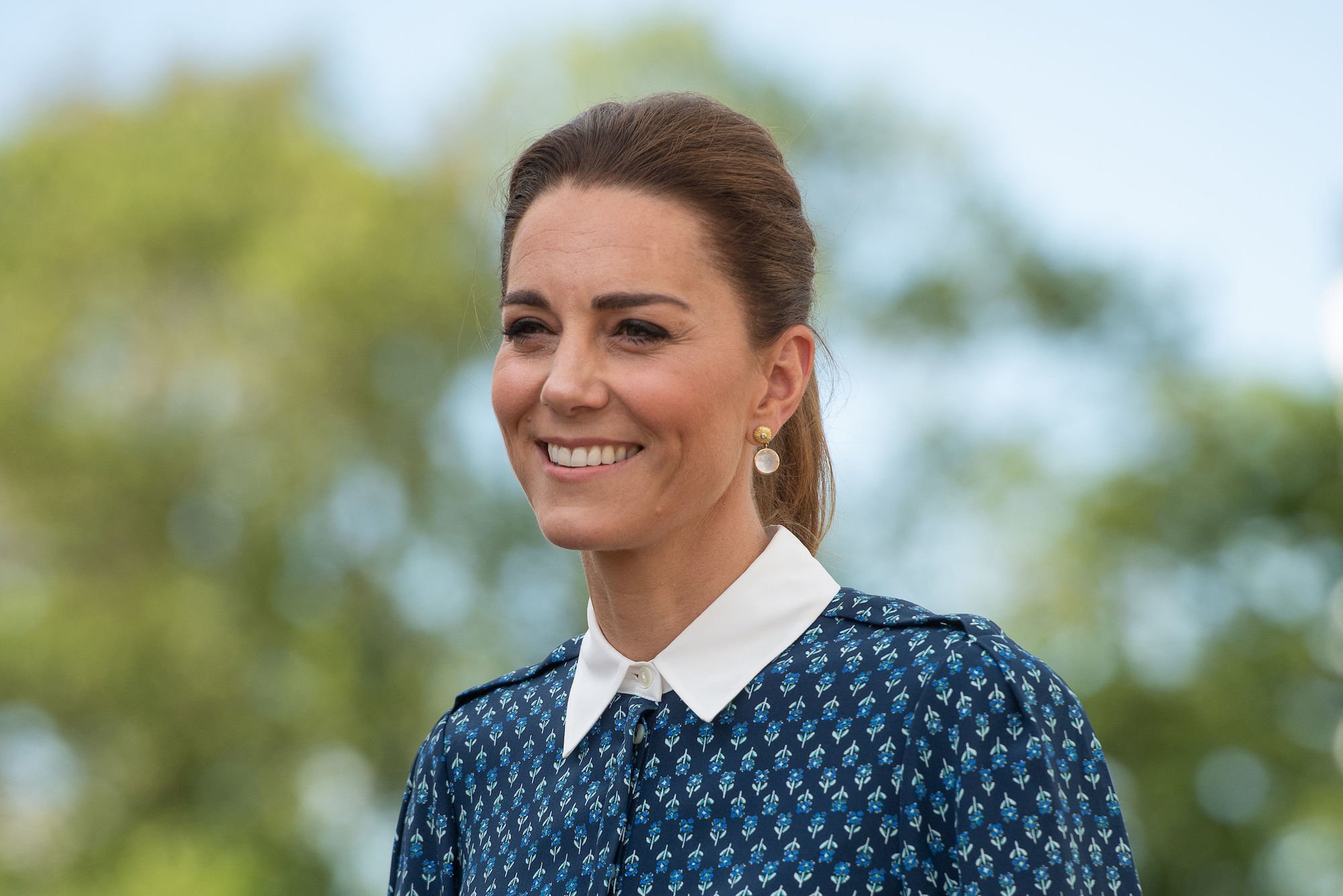 Kate Middleton smiling in front of a tree
