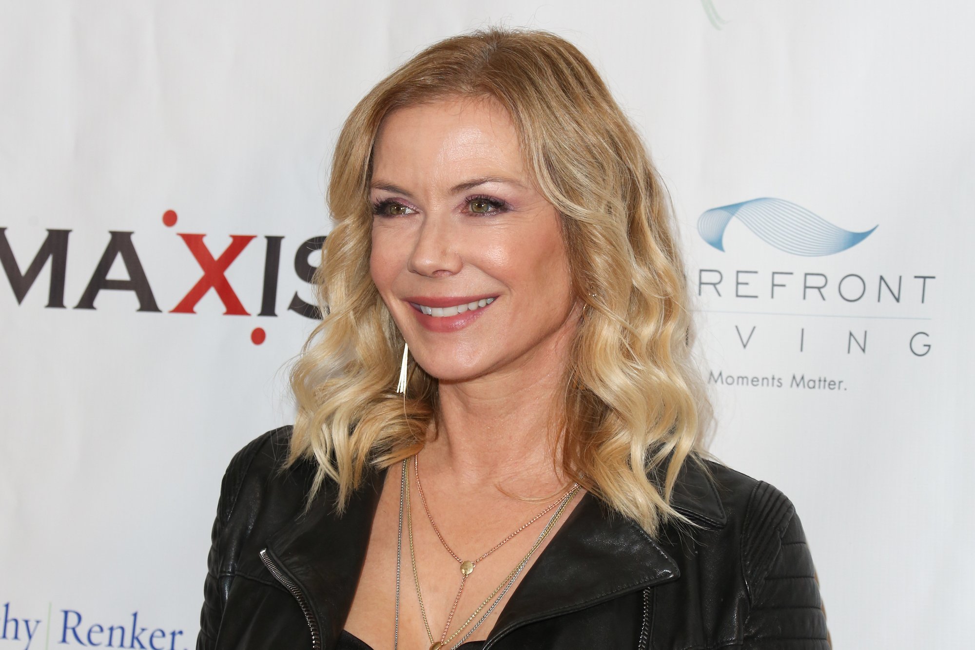 Katherine Kelly Lang smiling in front of a white wall