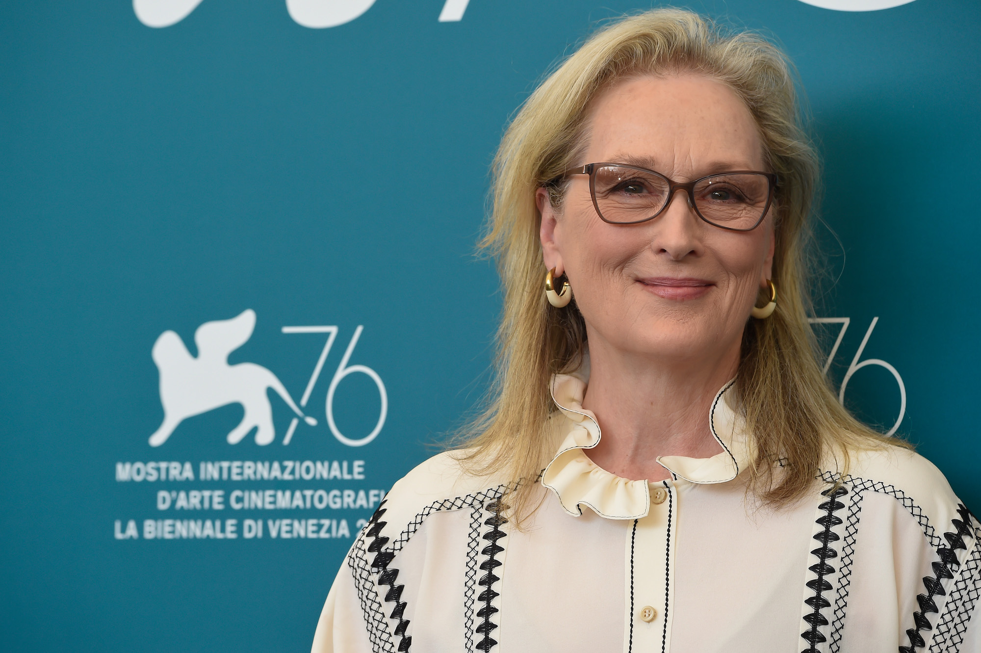 Meryl Streep smiling in front of a blue background