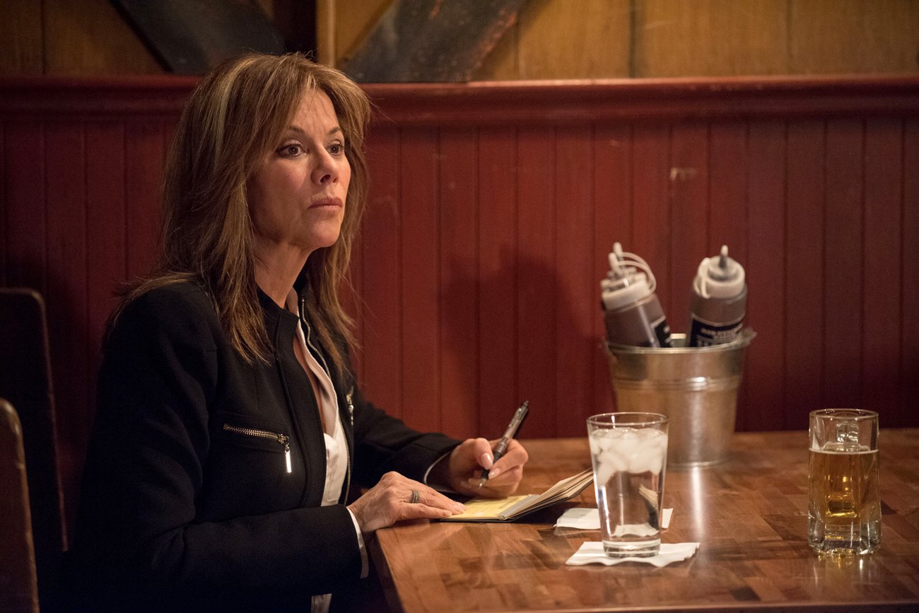 Nancy Lee Grahn writing at a table in a scene from 'General Hospital'