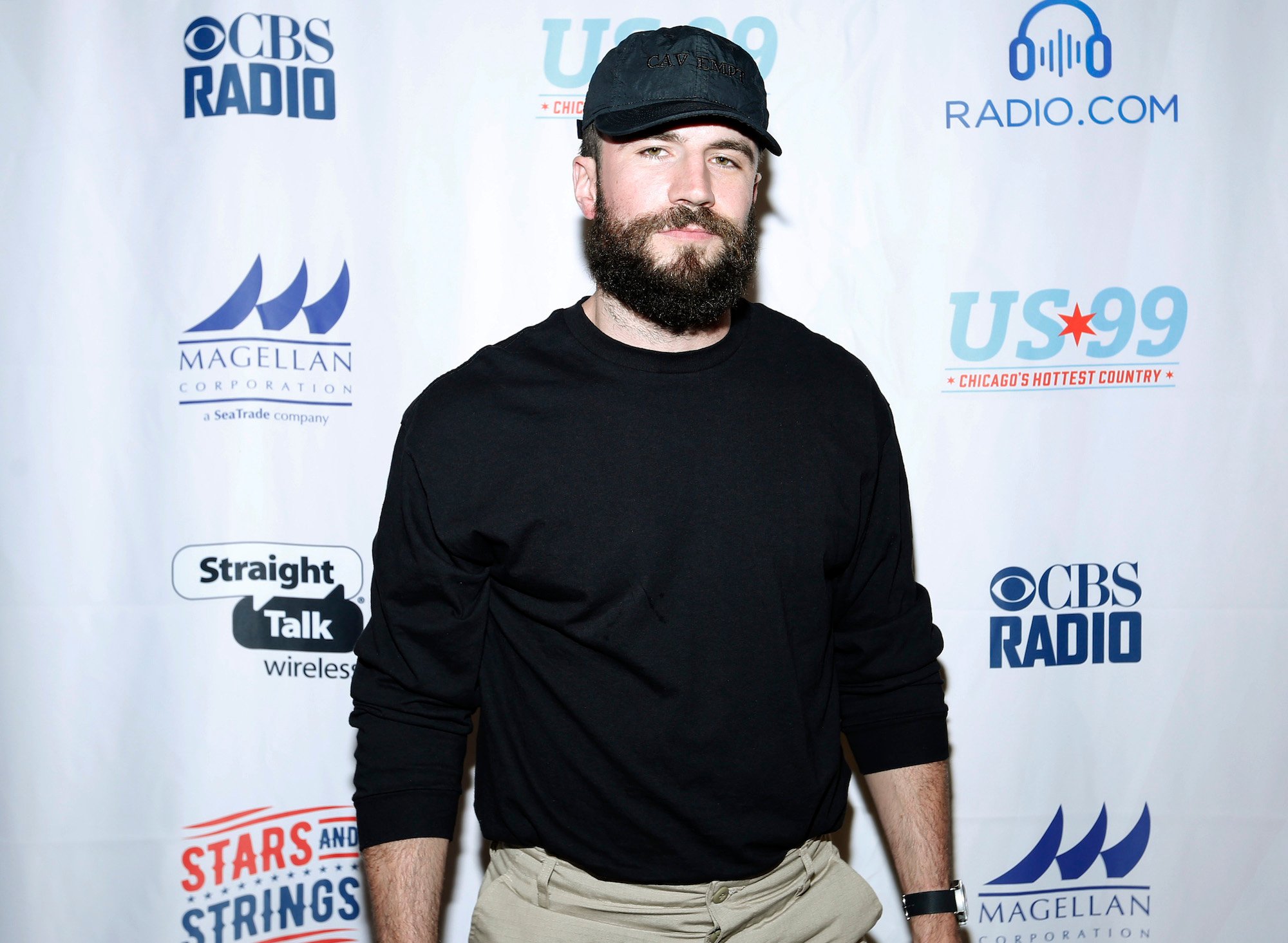 Sam Hunt smiling in front of a white background