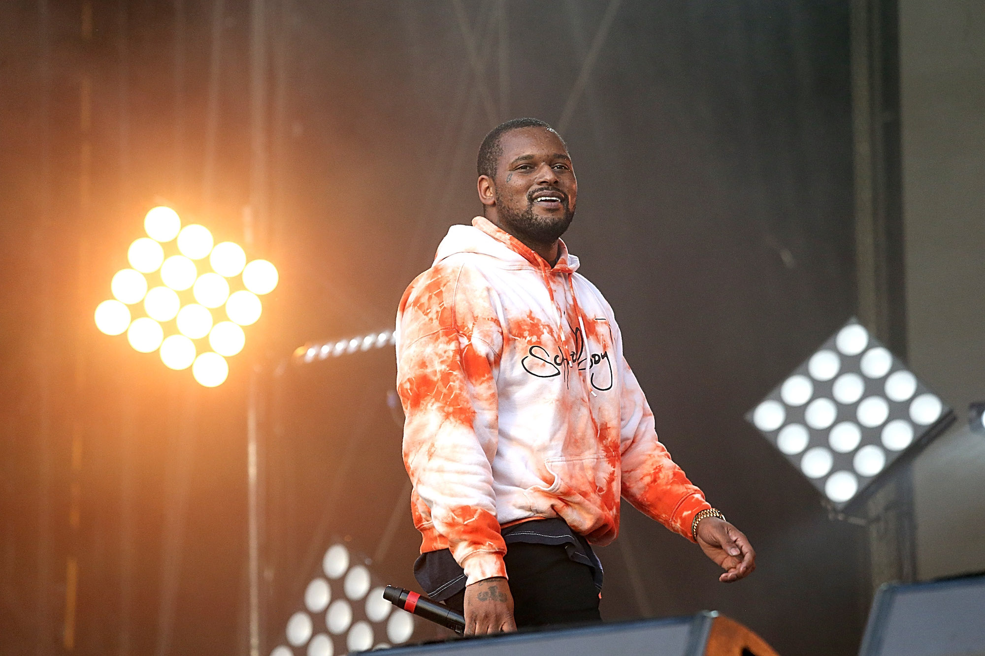 ScHoolboy Q smiling in front of stage lights