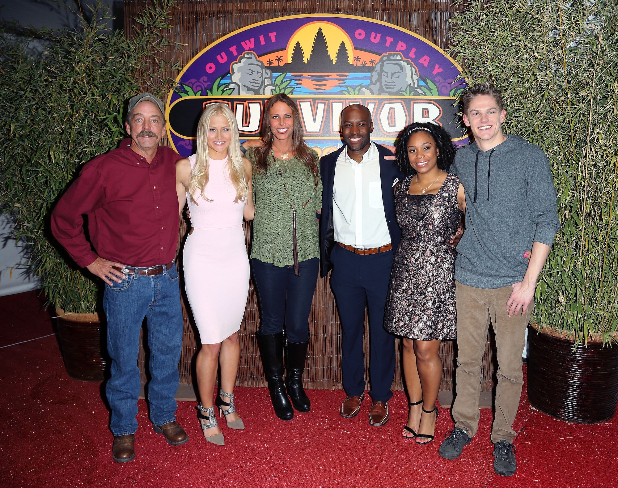 (L-R) Contestants Keith Nale, Kelley Wentworth, Kimmi Kappenberg, Jeremy Collins, Latasha "Tasha" Fox and Spencer Bledsoe smiling in front of a 'Survivor' logo
