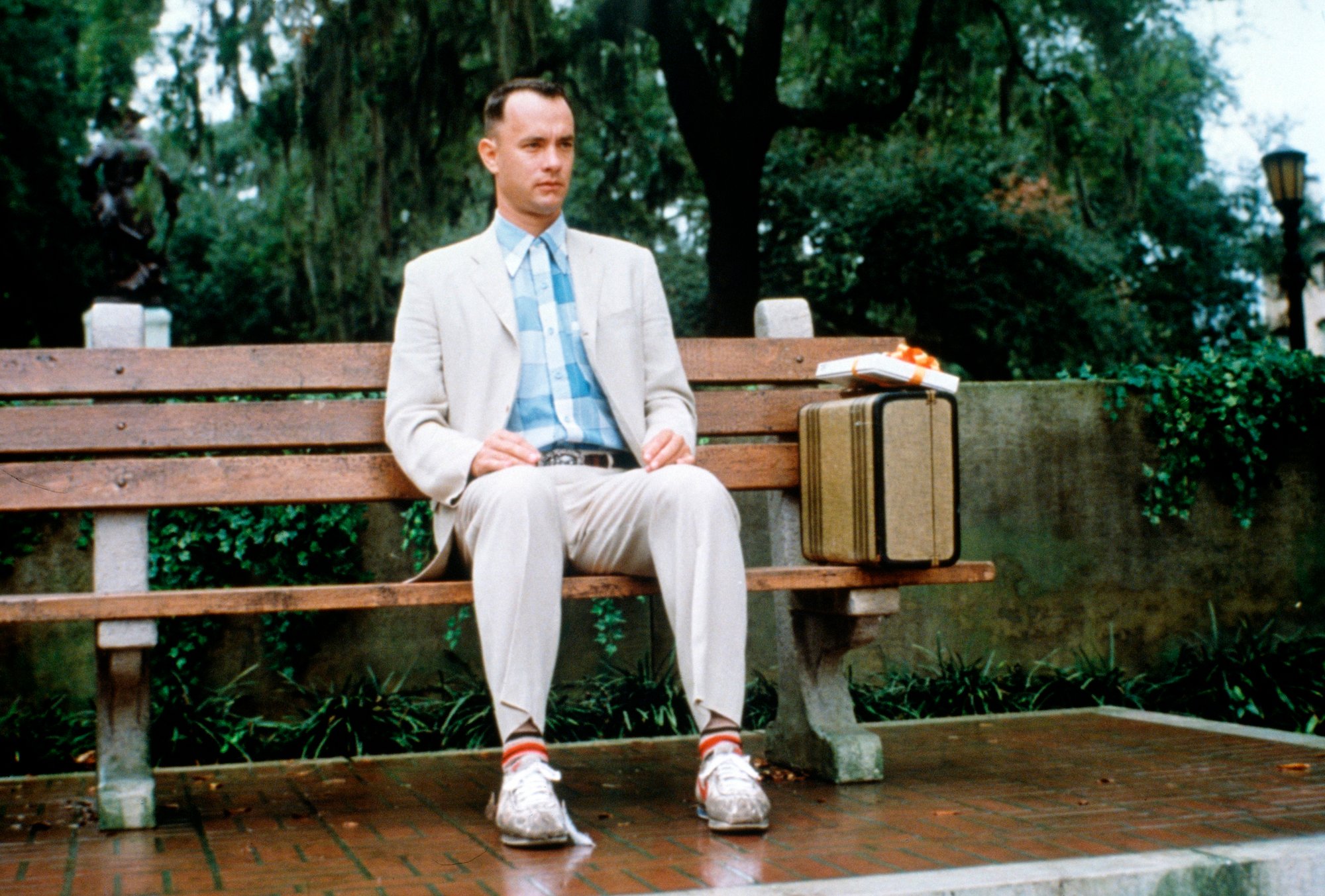 Tom Hanks as Forrest Gump sitting on a bench