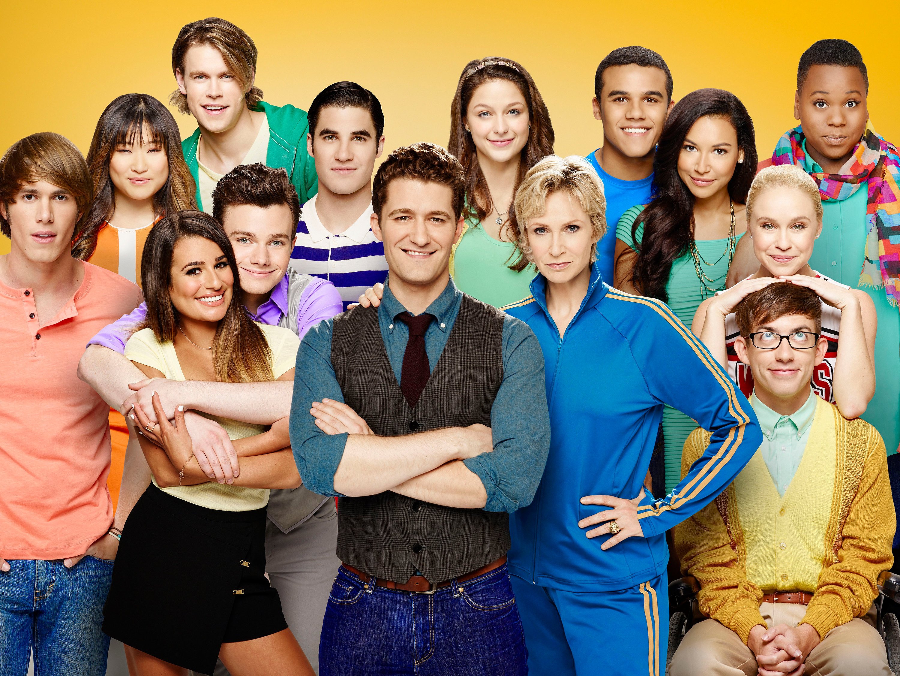 The cast of Glee in front of a yellow background