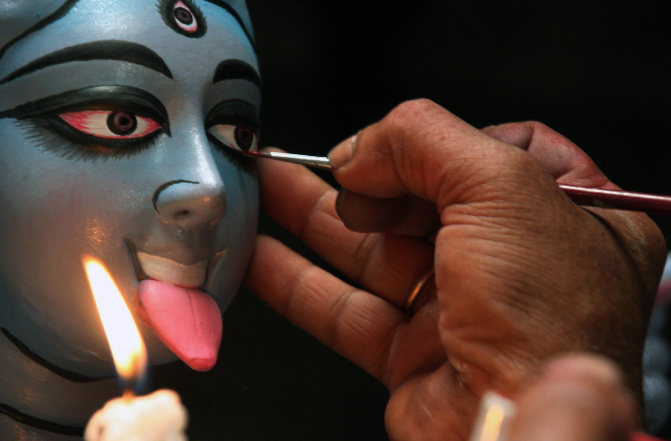 Someone painting an idol of Kali