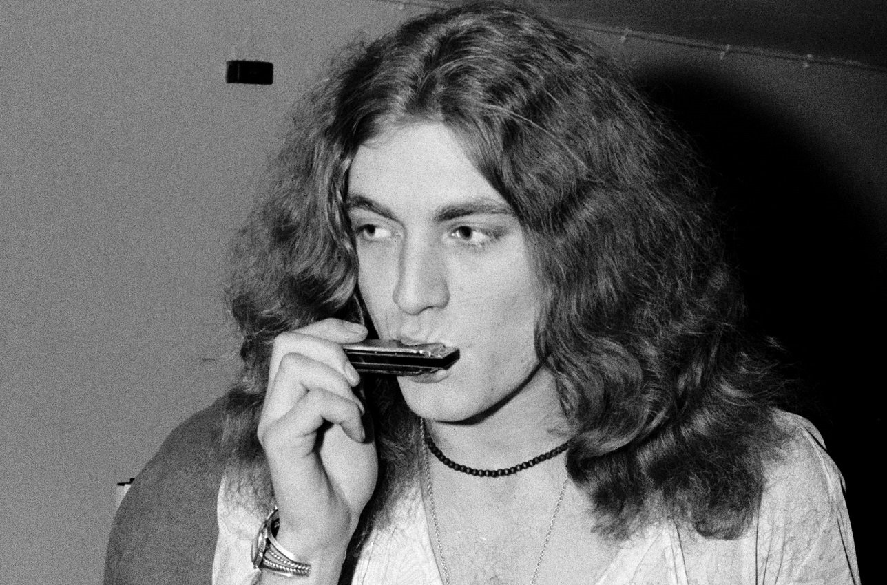 Robert Plant playing a harmonica
